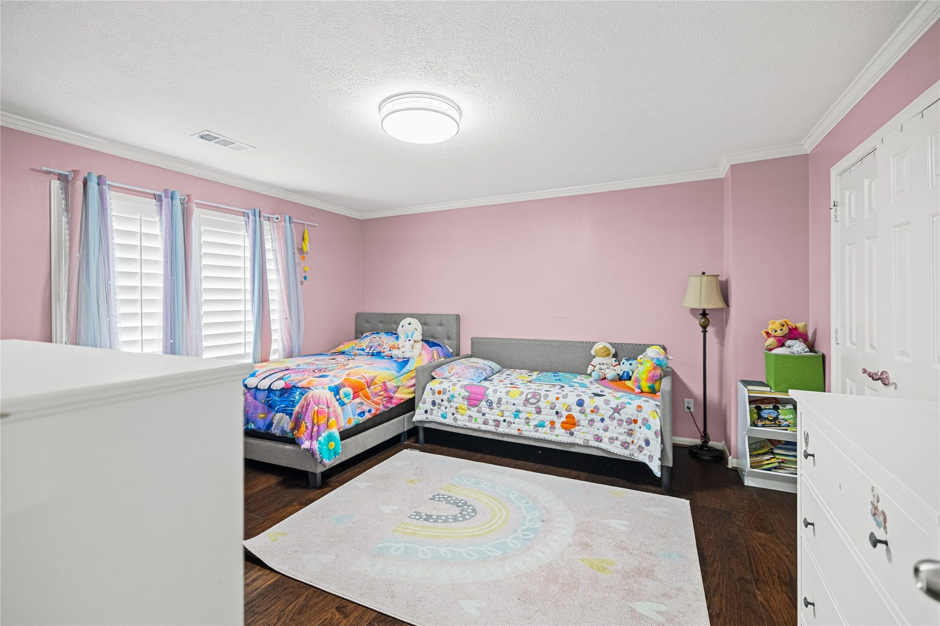 Generously sized secondary bedroom with engineered wood flooring, plantation shutters, and plenty of space for furnishings.