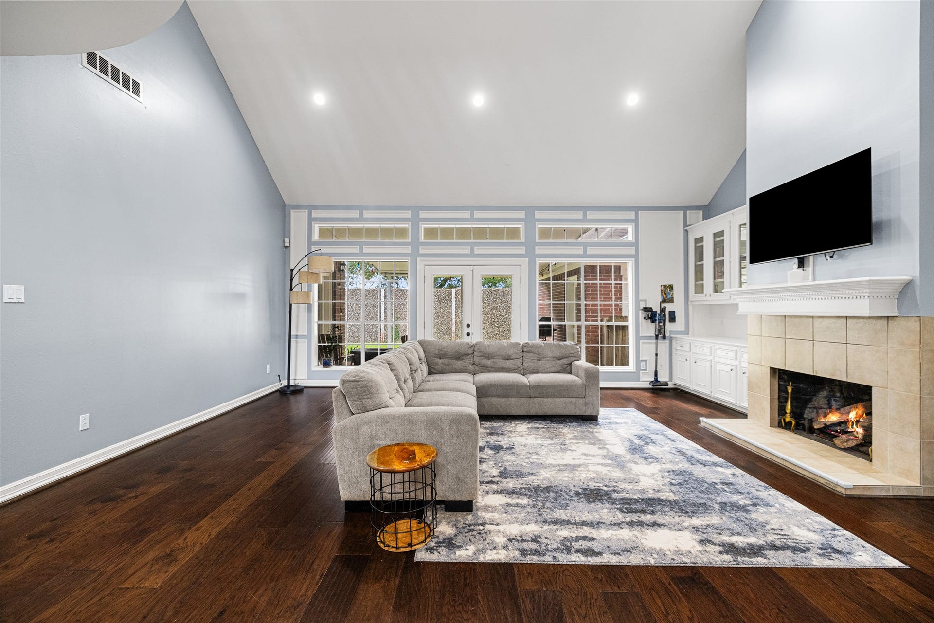 Beautiful family room showcasing extensive built-in cabinetry, fireplace, recessed lighting, and direct access to the covered backyard patio.