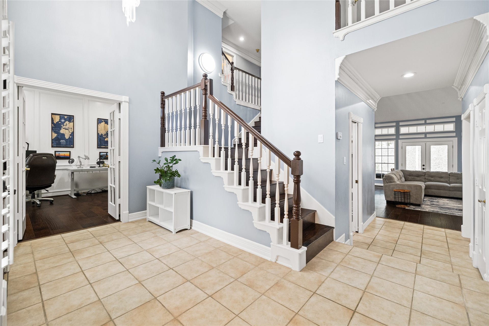 Spacious entryway with tile flooring and impressive staircase, offering convenient access to the private home office and two-story family room.