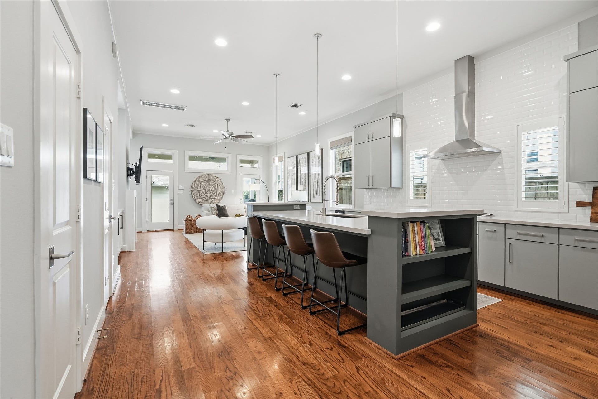 813 Ashland Street, Houston, TX 77007 Chefs kitchen features an oversized island with bar seating, abundant cabinetry, stainless steel appliances, and a spacious walk-in pantry, all seamlessly connected to the home's open-concept living and dining areas.
