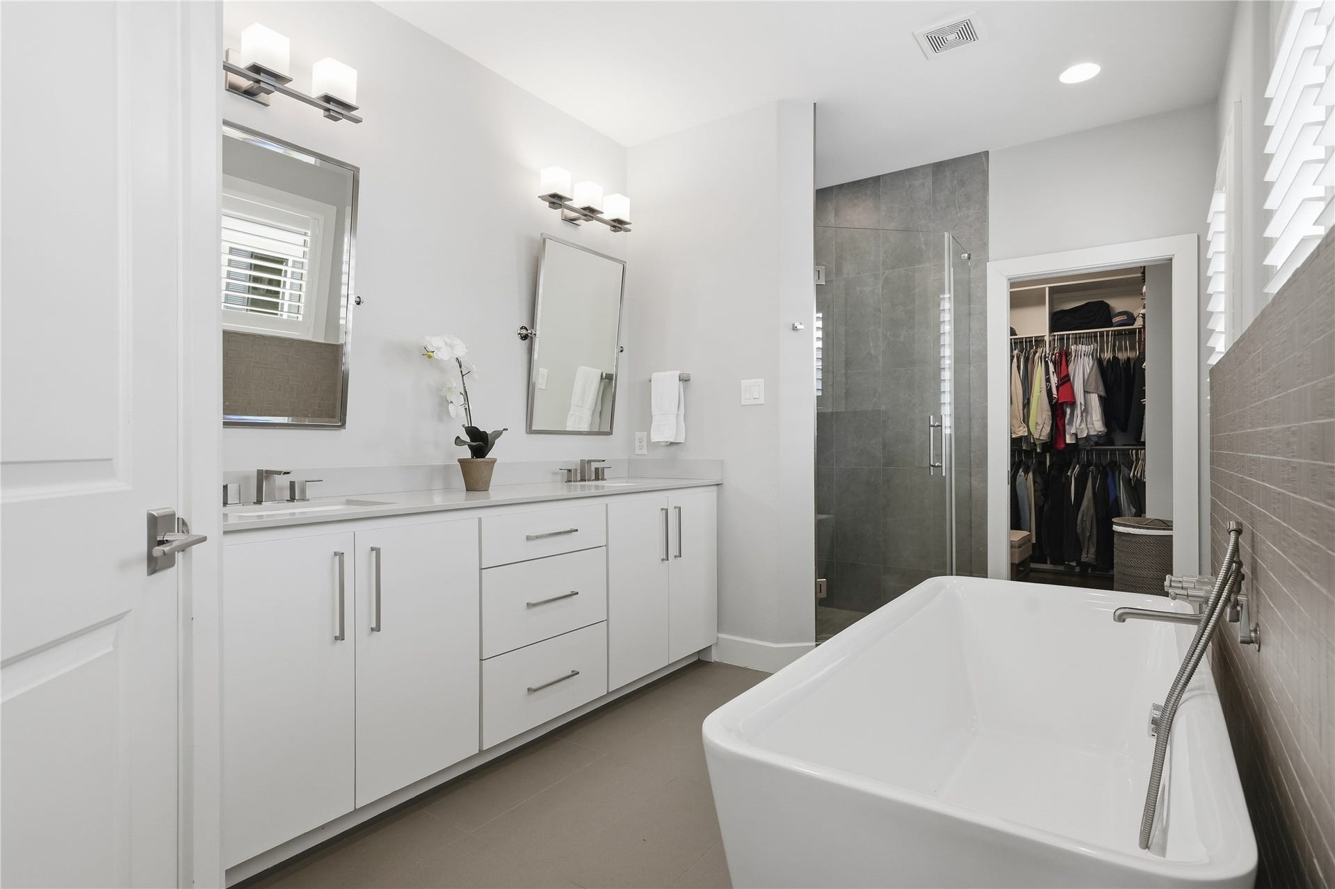 813 Ashland Street, Houston, TX 77007 The spa-inspired primary bath features dual vanities, a freestanding soaking tub, a spacious walk-in shower, and a private water closet.