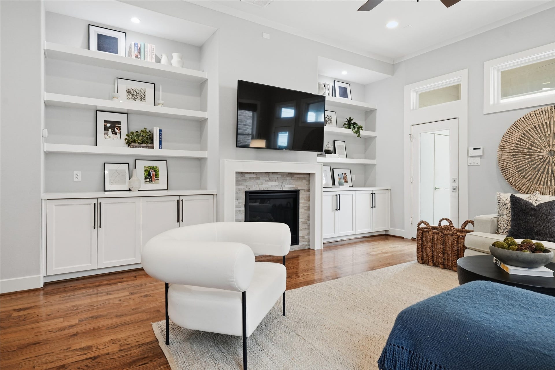 813 Ashland Street, Houston, TX 77007 The light-filled living room showcases a gas fireplace framed by custom built-ins, creating an inviting space for relaxation and gathering.