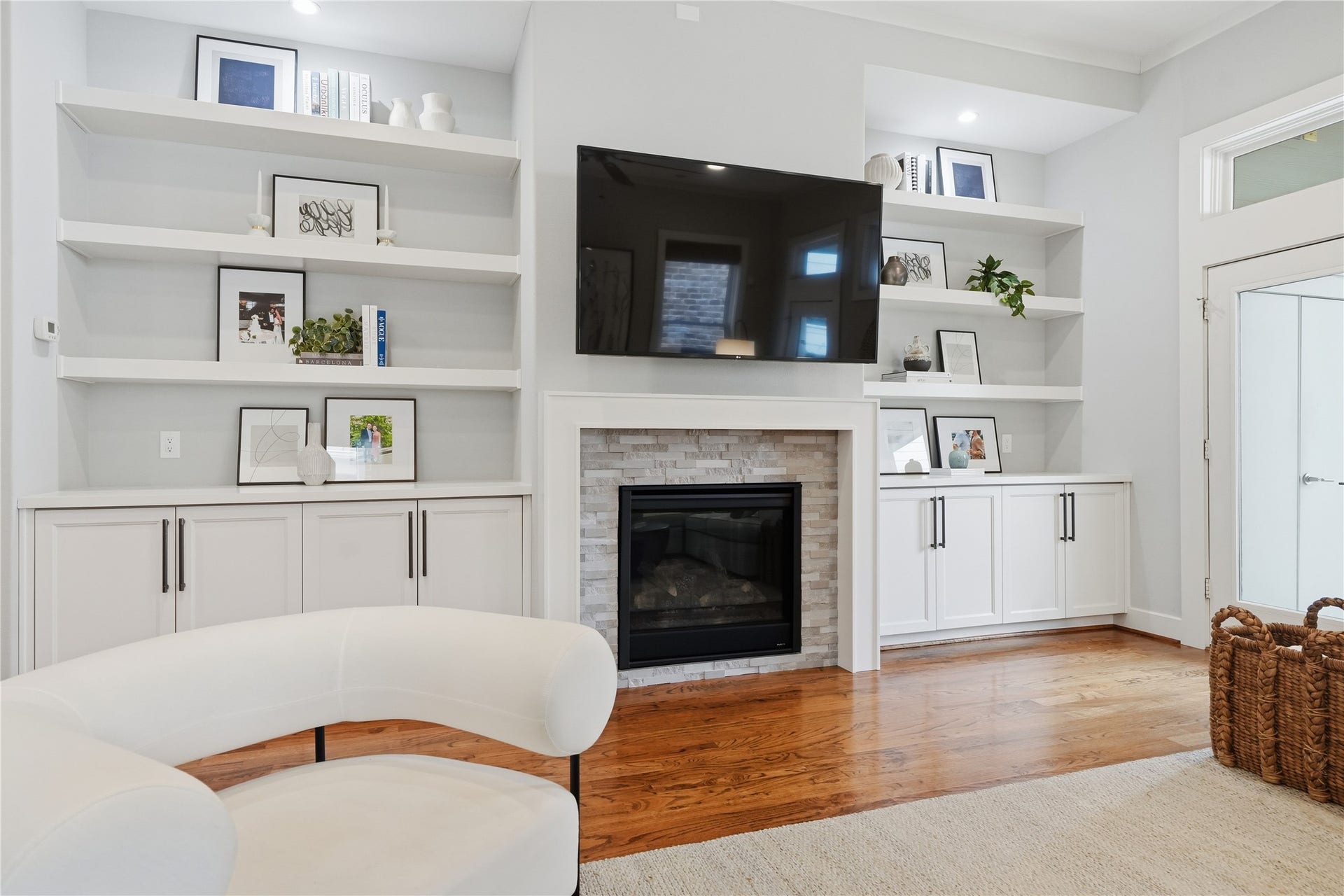 813 Ashland Street, Houston, TX 77007 The light-filled living room showcases a gas fireplace framed by custom built-ins, creating an inviting space for relaxation and gathering.
