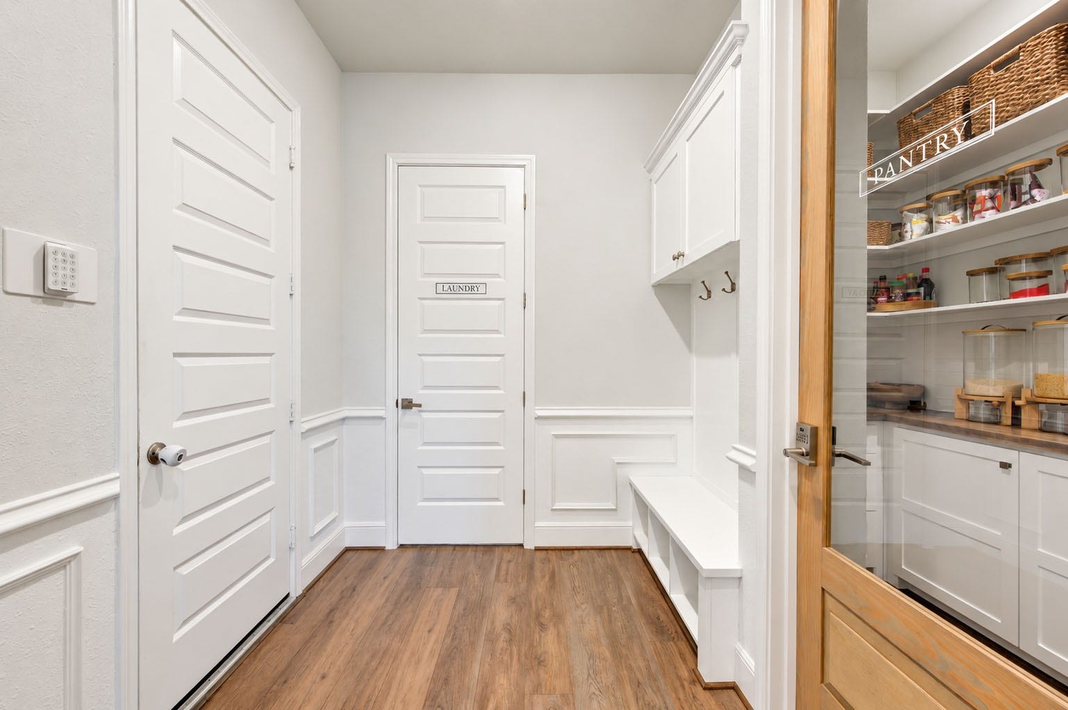 2803 Enriched Enclave Court, Richmond, TX 77406 Beautifully designed mud room featuring custom built-in bench seating, storage cabinetry, decorative millwork, and convenient access to the laundry room and walk-in pantry.