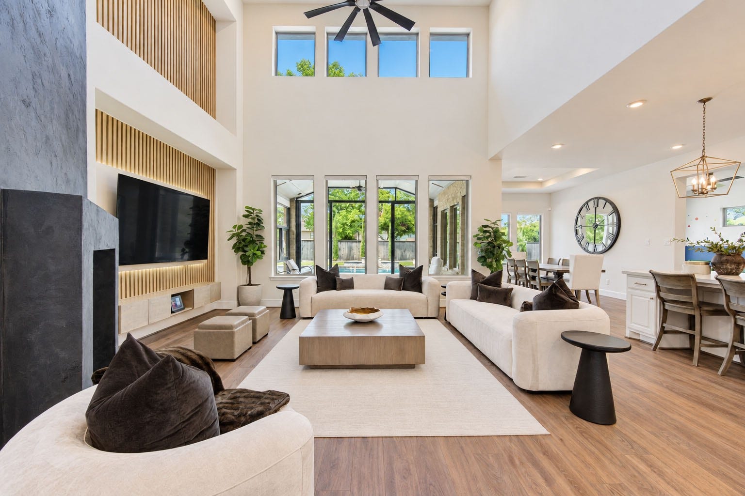 2803 Enriched Enclave Court, Richmond, TX 77406 Dramatic two-story family room featuring soaring ceilings, walls of windows, and a striking contemporary fireplace and media wall.