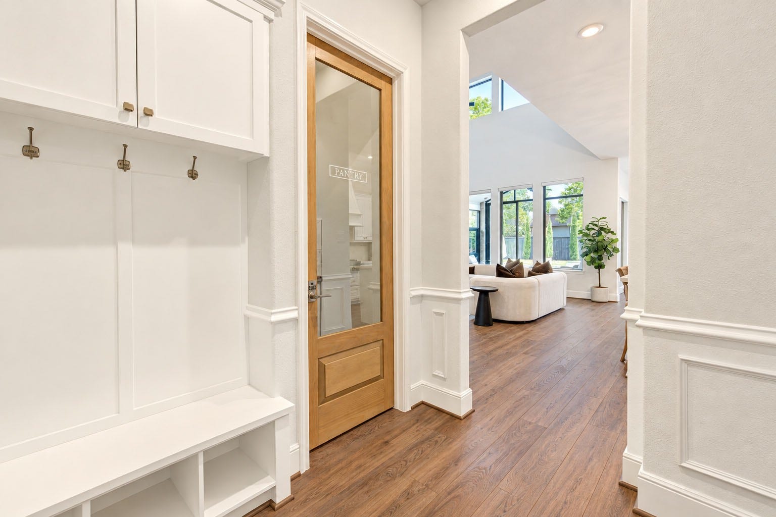 2803 Enriched Enclave Court, Richmond, TX 77406 Beautifully designed mud room featuring custom built-in bench seating, storage cabinetry, and decorative millwork. A phenomenal custom wood-and-glass pantry door adds warmth and character while providing a stylish entrance to the walk-in pantry.