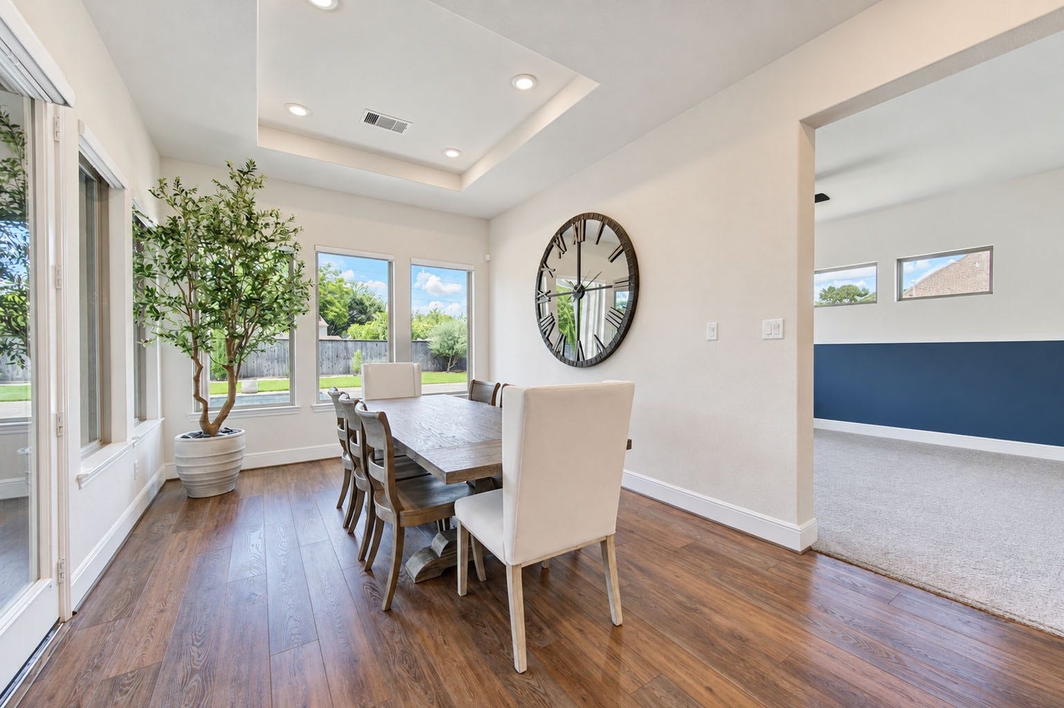 2803 Enriched Enclave Court, Richmond, TX 77406 Light-filled dining space featuring warm wood flooring, tray ceiling, and beautiful backyard views.