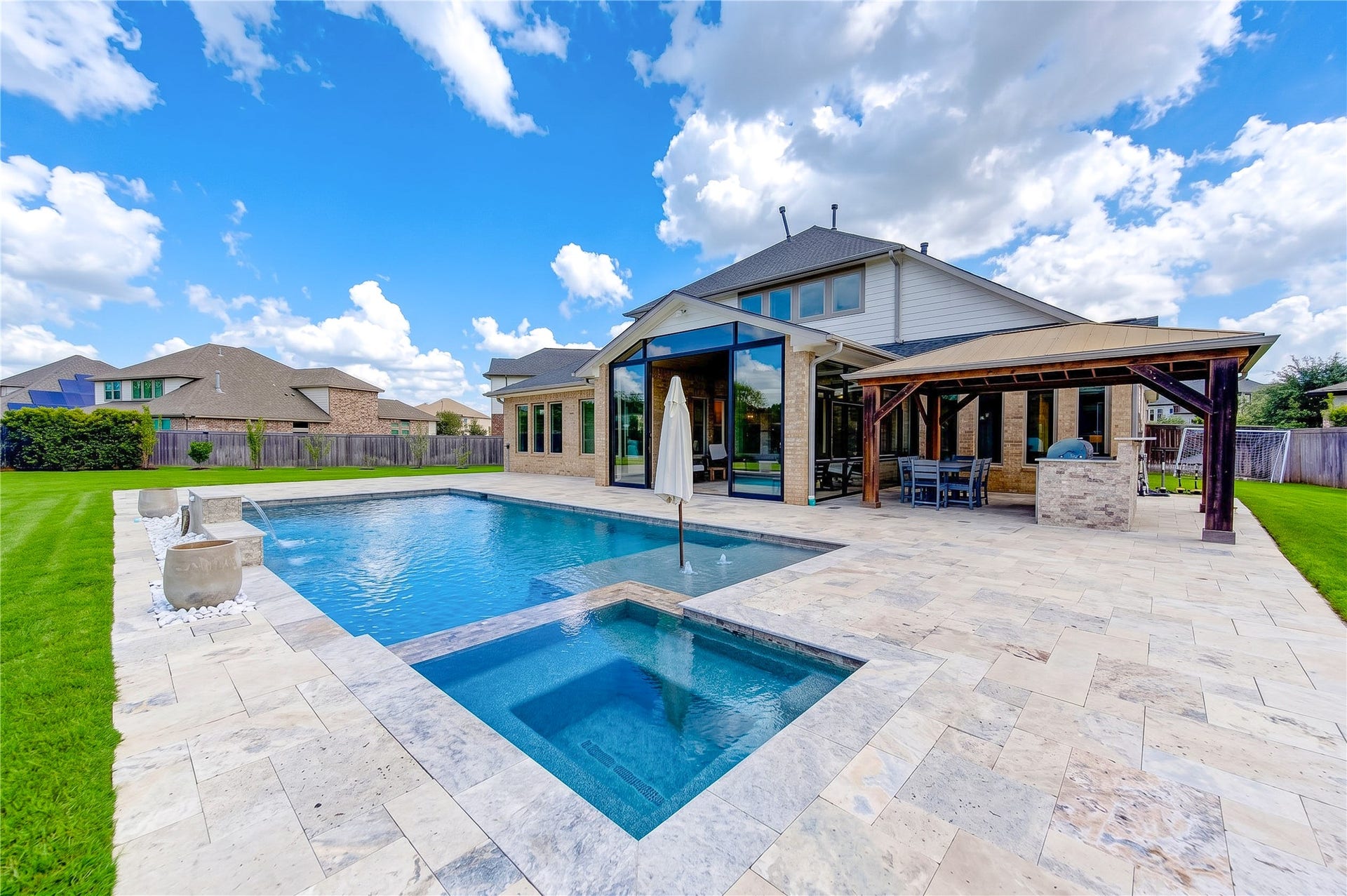 2803 Enriched Enclave Court, Richmond, TX 77406 Spectacular backyard retreat featuring a sparkling pool and spa, expansive patio, and covered outdoor living areaperfect for entertaining.