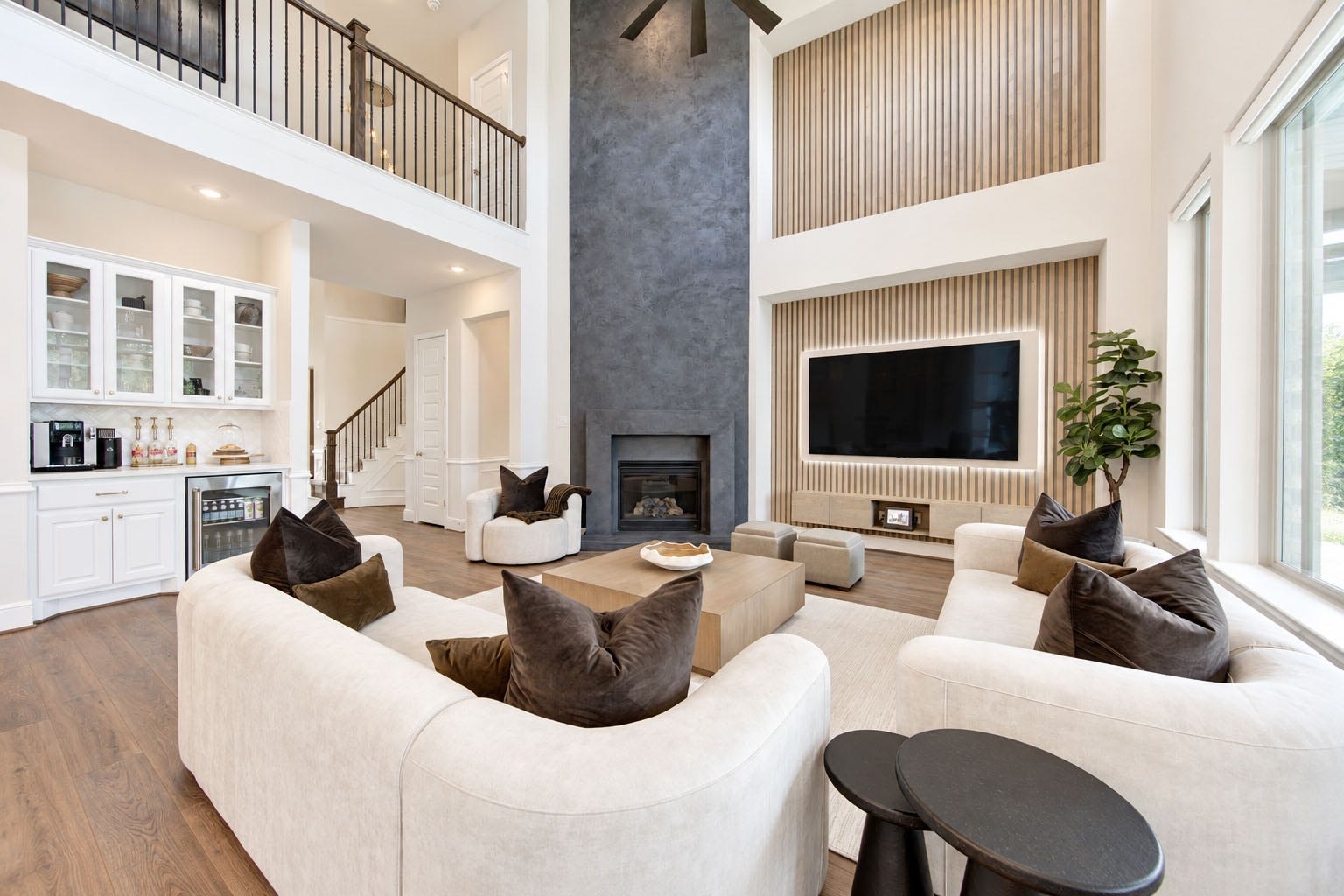 2803 Enriched Enclave Court, Richmond, TX 77406 Showstopping two-story family room with a dramatic fireplace, custom media wall, and built-in wet bar.