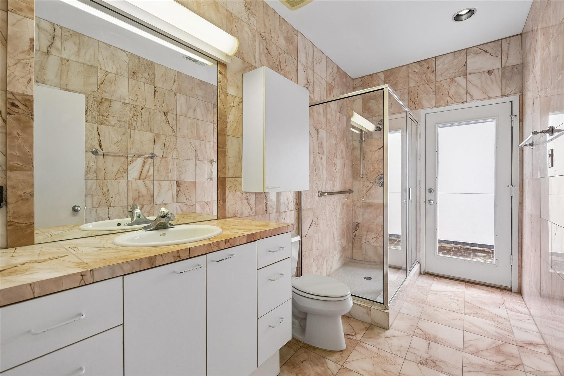 HERE WE HAVE THE ELEGANT AND BEAUTIFUL GUEST BATHROOM.  LOTS OF STORAGE AND HUGE STAND-UP SHOWER AND YES THAT IS A LOVELY BALCONY JUST OUTSIDE.