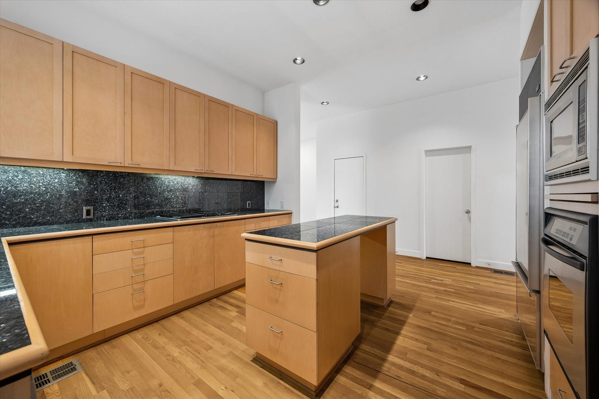 ANOTHER VIEW OF THE SLICK-LINE KITCHEN, UNDER CABINET LIGHTING AND TONS AND TONS OF RECESSED LIGHTING THROUGHOUT THIS BEAUTIFUL HOME.
