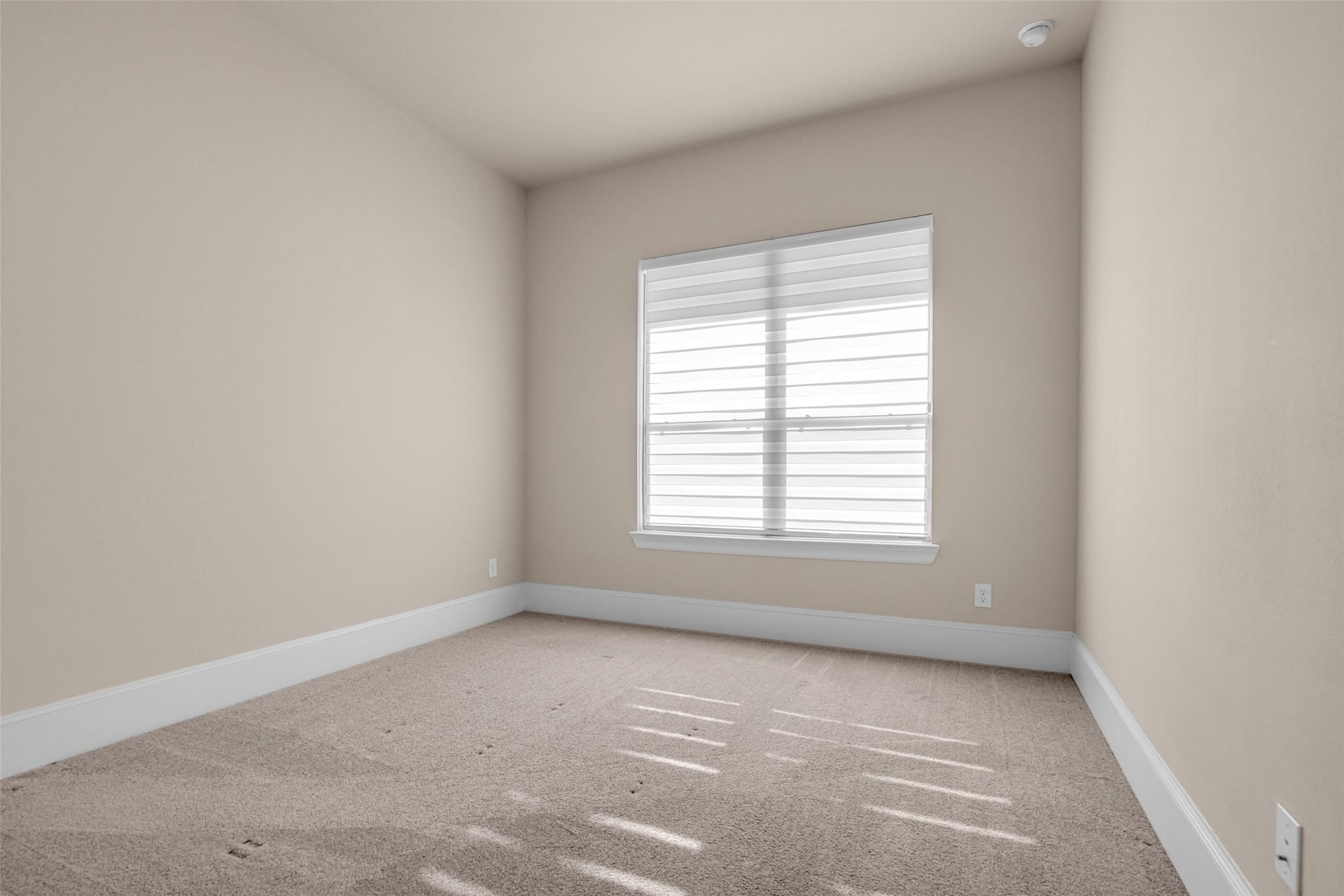 2718 Newbury Island Lane, Katy, TX 77493 A first-floor secondary bedroom with windows overlooking the front lawn, providing natural light and a pleasant view.