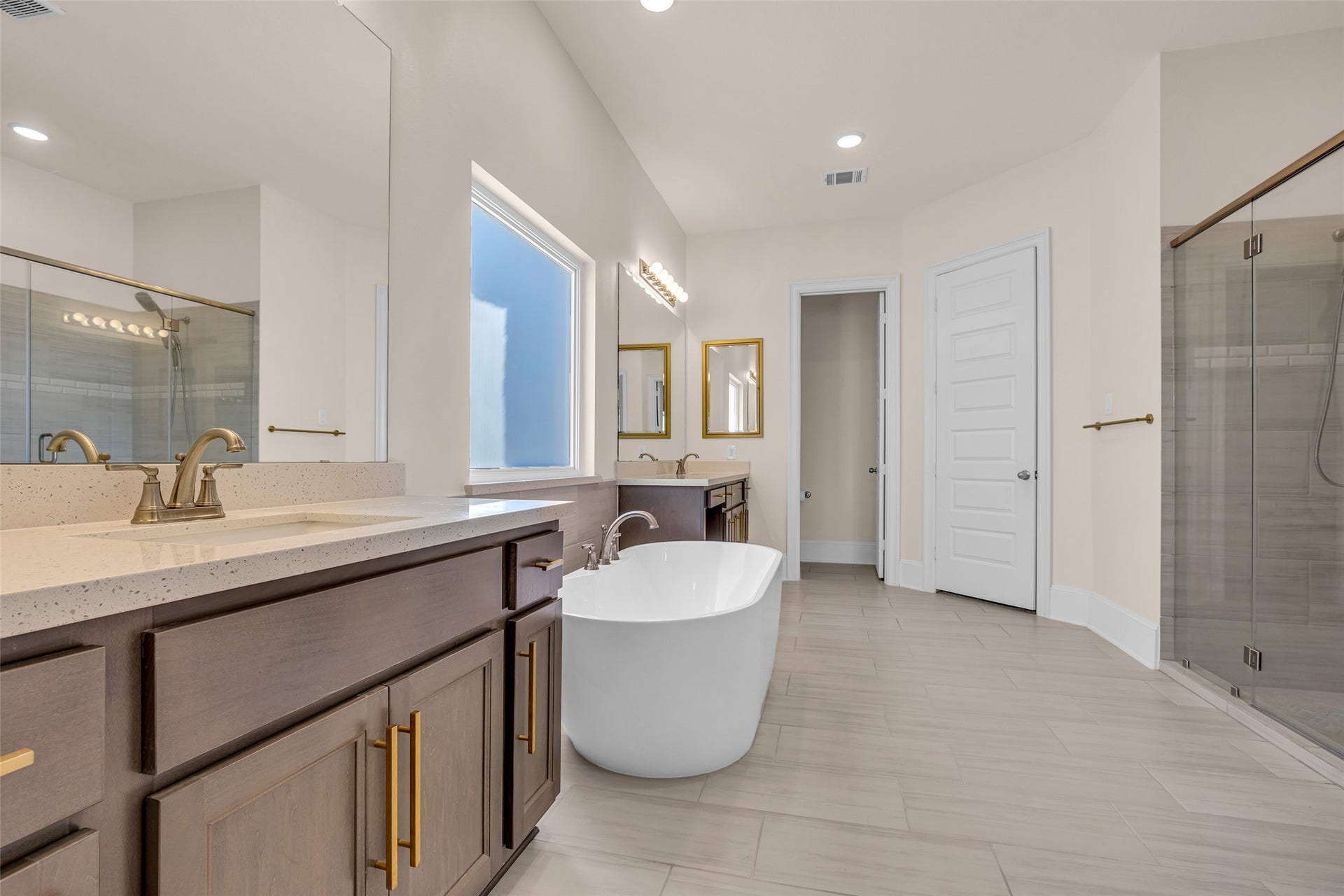 2718 Newbury Island Lane, Katy, TX 77493 The primary bedroom includes a spacious bathroom with a separate tub and shower, dual sinks, and two walk-in closets for plenty of storage.