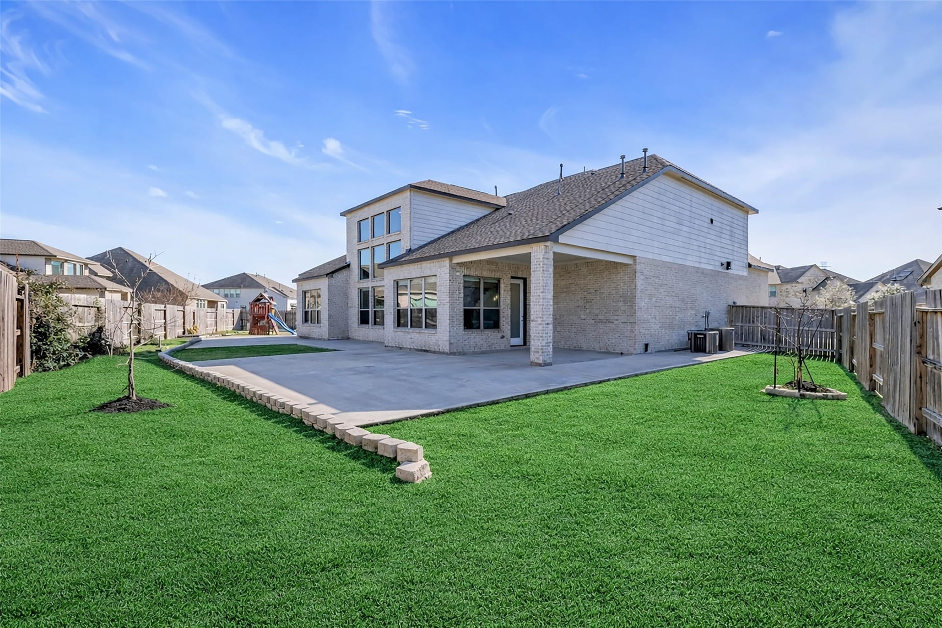 2718 Newbury Island Lane, Katy, TX 77493 The back of the house features a covered patio and a wide backyard, perfect for outdoor activities and gatherings.