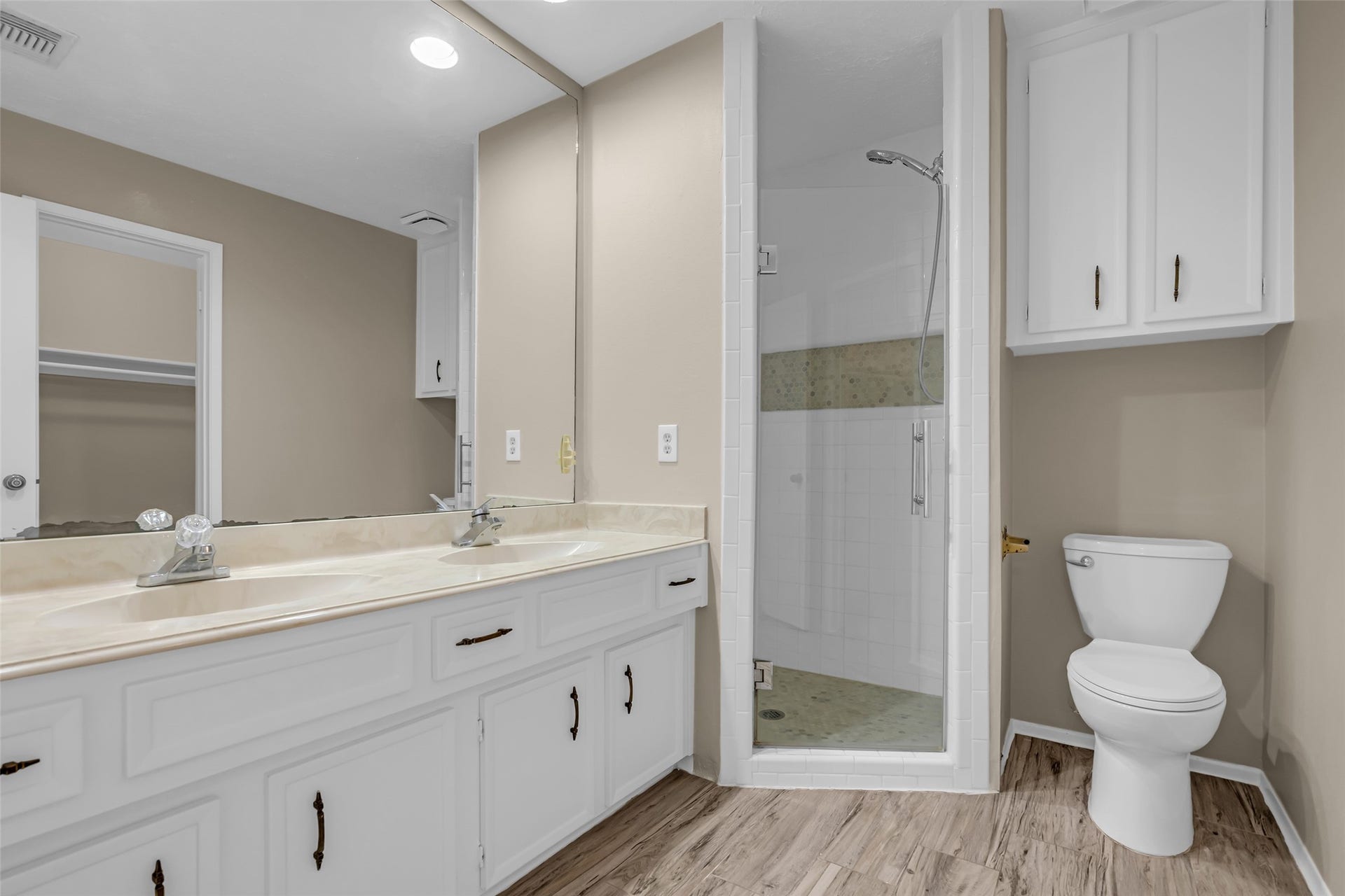 11827 Brook Meadows Lane, Meadows Place, TX 77477 The en suite Primary bathroom features a spacious layout with a double-sink vanity, a glass-enclosed shower, and a toilet.
