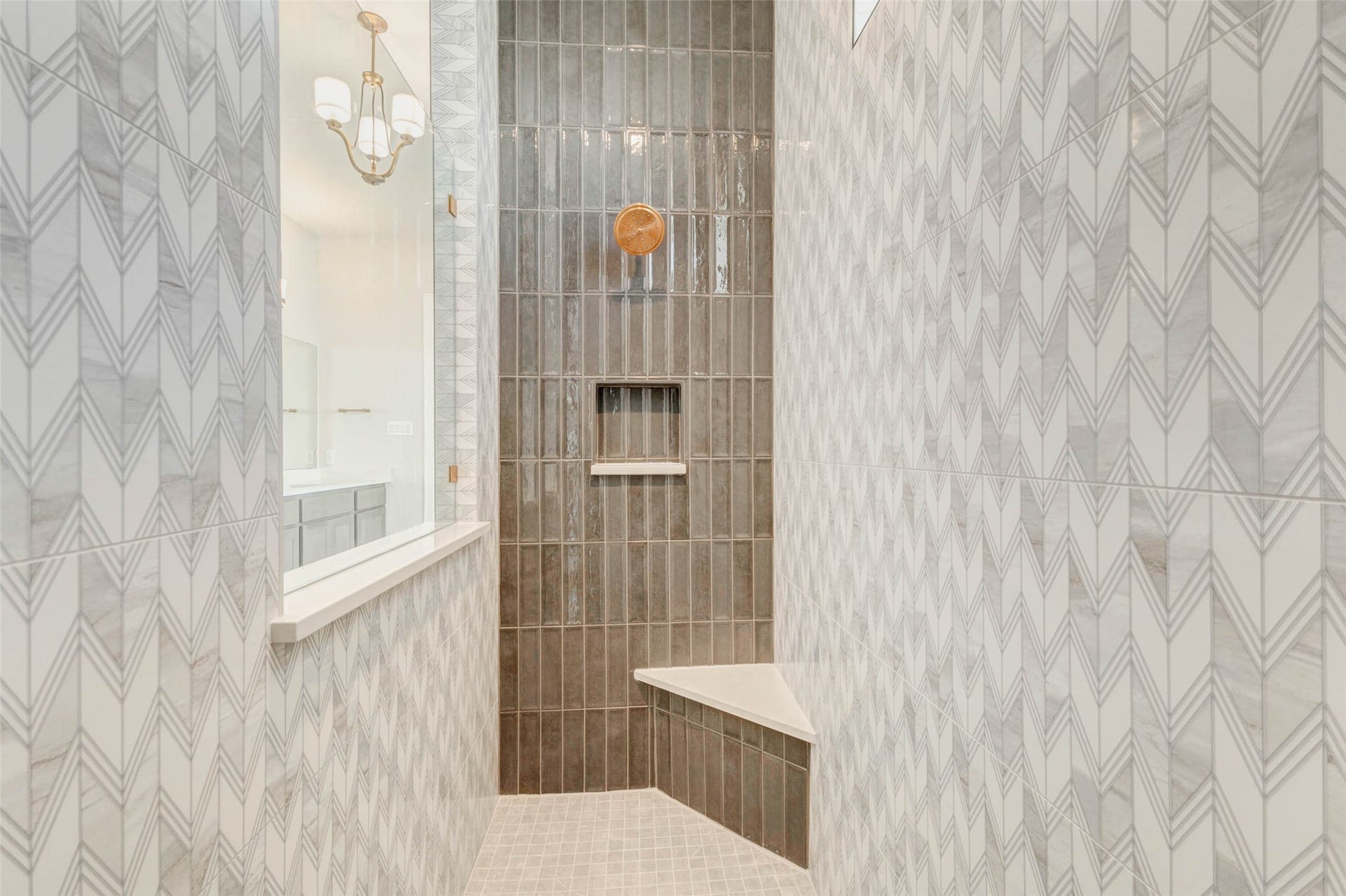 Modern shower with elegant tile work and a sleek built-in bench. The neutral color scheme and stylish fixtures create a luxurious and inviting atmosphere.