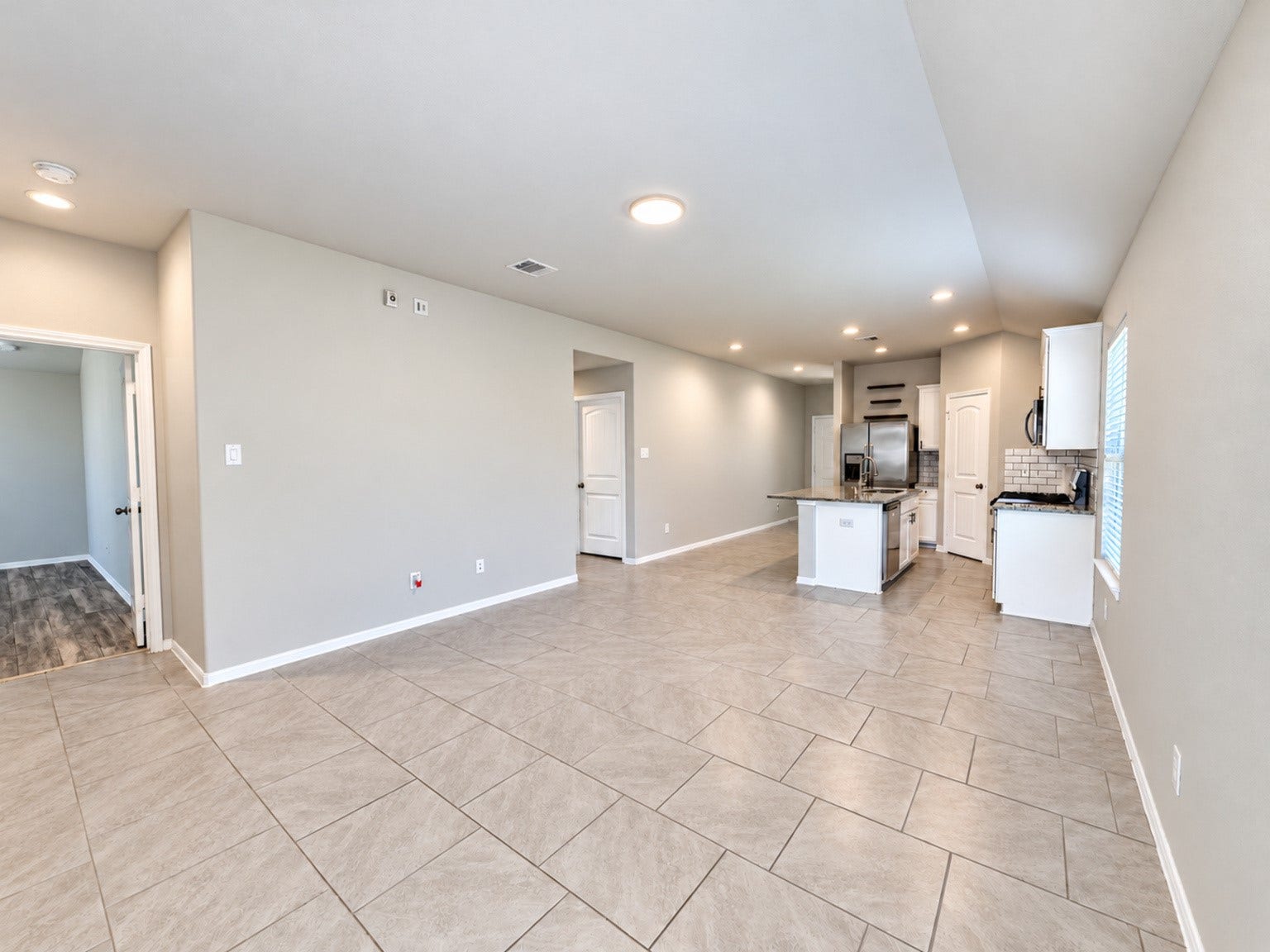 29202 Dunns Creek Court, Katy, TX 77494 Wide view of the living area, with windows bringing in natural light and an open flow to the kitchen.