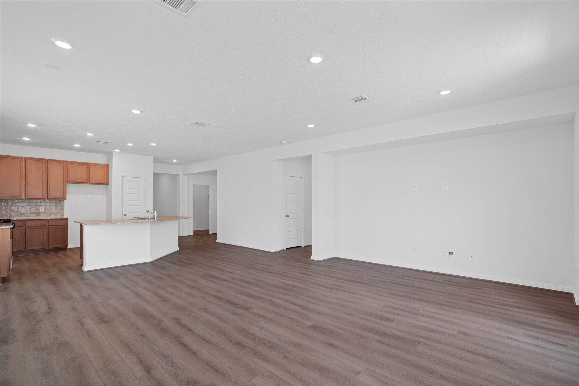 Additional view of the open concept living space with sightlines to the Den and hallway to entryway.