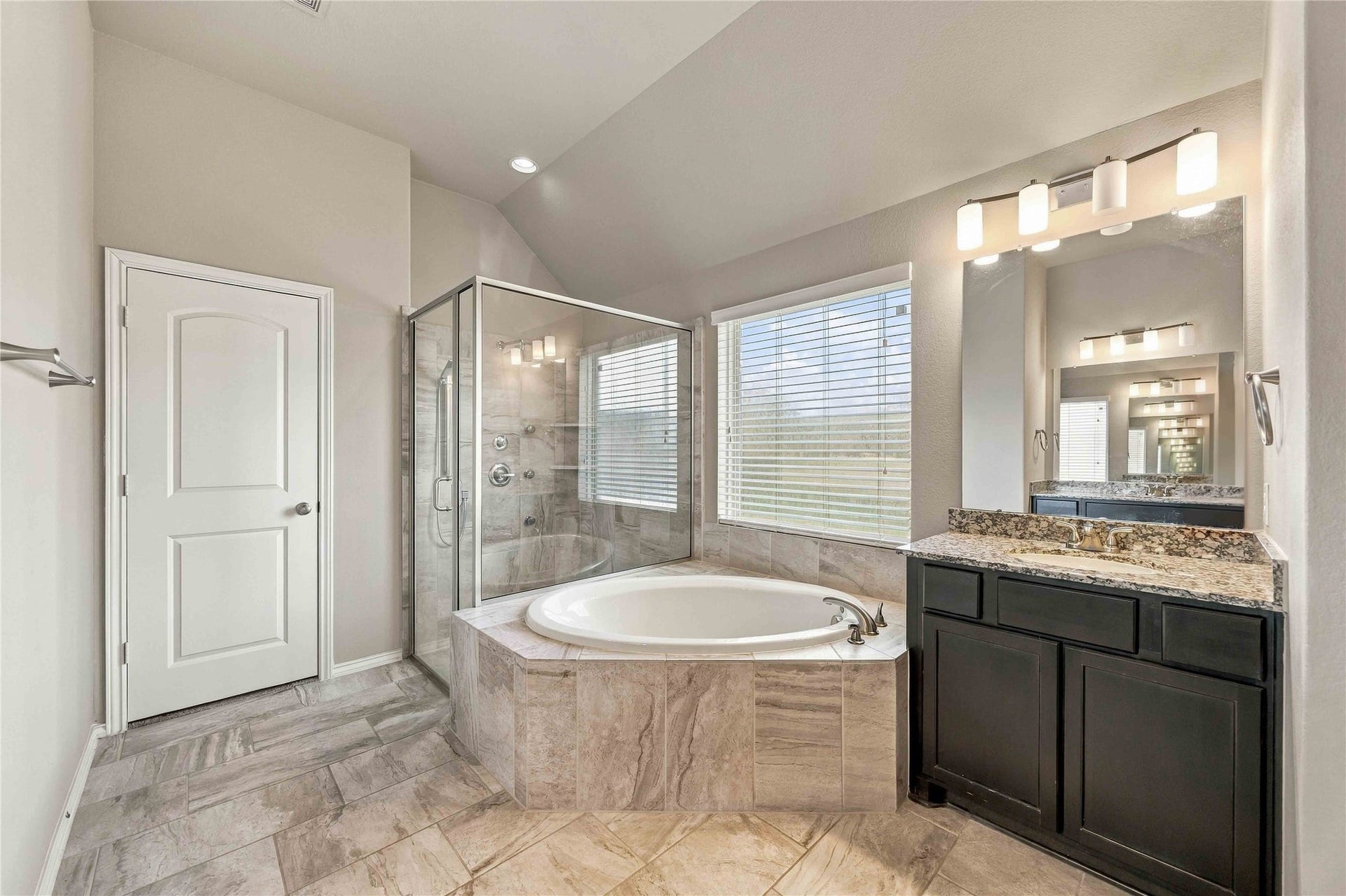 The spacious primary bathroom offers a spa-inspired retreat, featuring a separate soaking tub and walk-in shower. Designed for both comfort and convenience, this inviting space is the perfect place to relax and unwind.