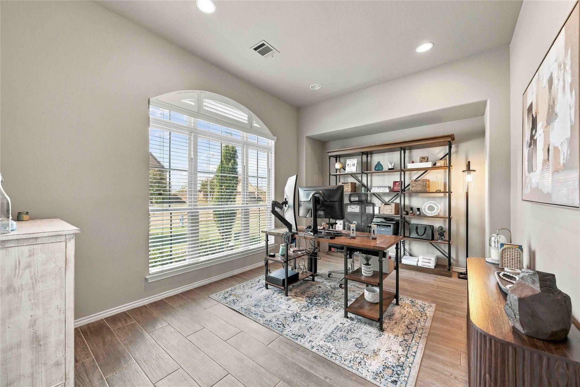 Bright and spacious home office featuring a large arched window that provides alot of natural light