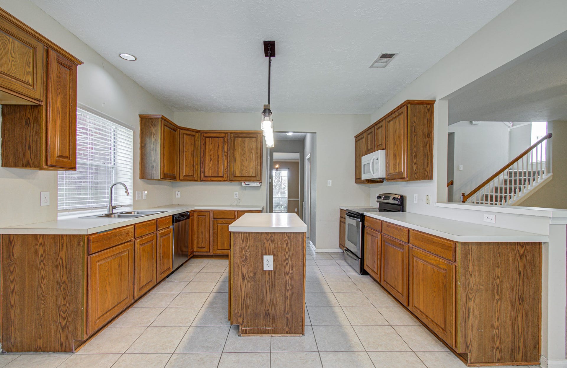 10003 Briarpark Trail Lane, Houston, TX 77064 Island kitchen features abundant wood cabinetry, generous counter space, a double sink and convenient access to the family room and breakfast nook.