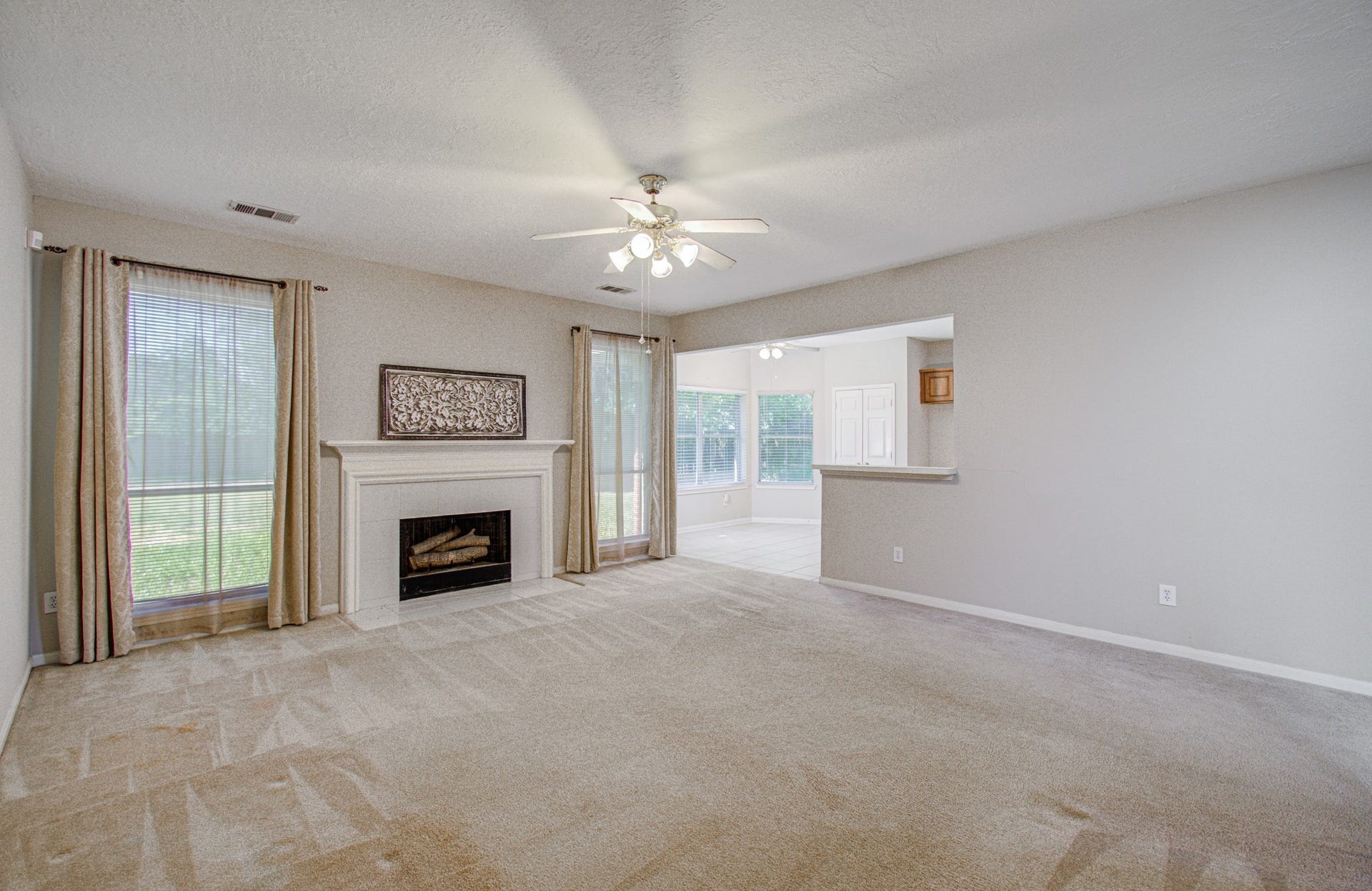 10003 Briarpark Trail Lane, Houston, TX 77064 Spacious family room features a fireplace, backyard-facing windows and an open connection to the kitchen and breakfast area.