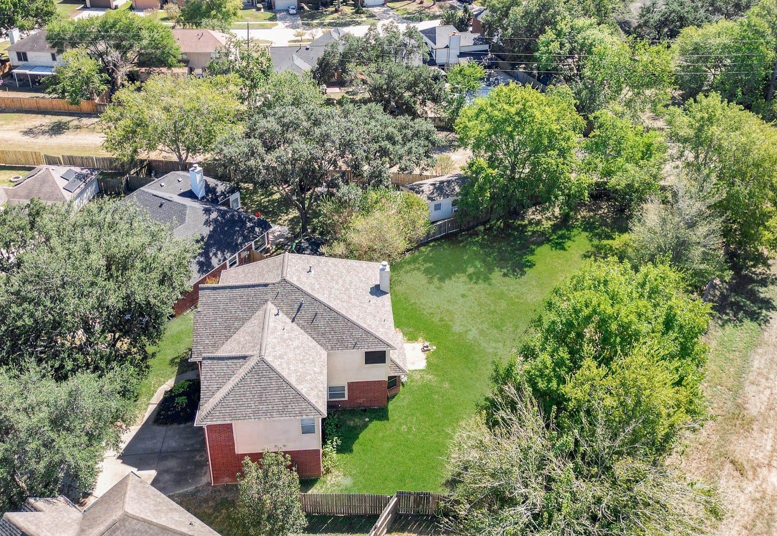 10003 Briarpark Trail Lane, Houston, TX 77064 A bird's-eye view showcases the impressive backyard, mature trees and generous outdoor space surrounding the home.