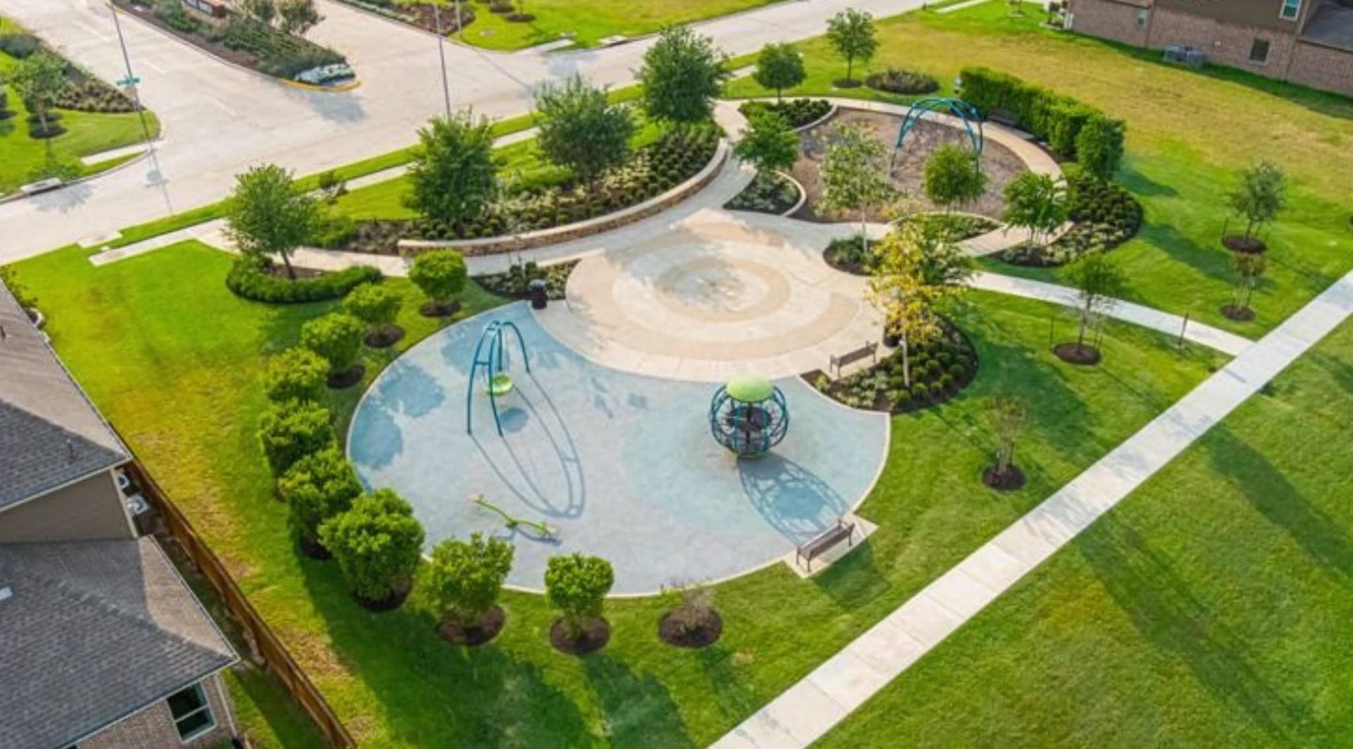 A beautifully landscaped community park featuring modern play equipment, lush greenery, and winding pathways, perfect for family outings and relaxation.