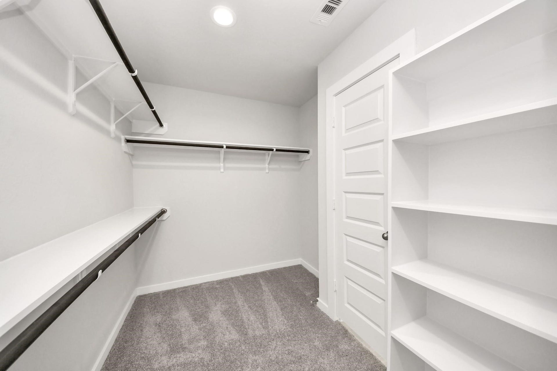 Spacious walk-in closet featuring ample shelving and hanging space for organized storage.