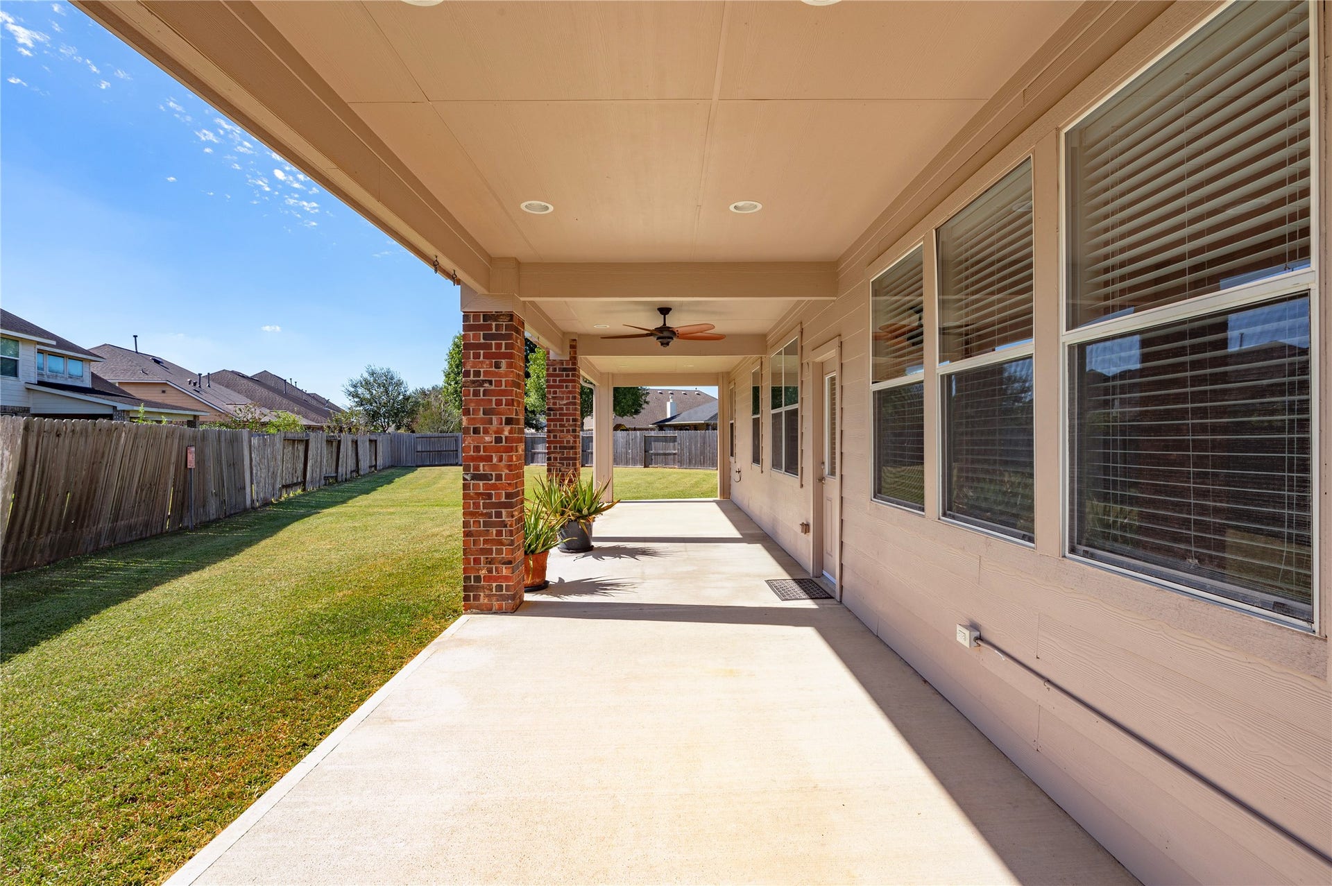 4404 Cypress Meadows Court, Dickinson, TX 77539 The large covered back patio with brick columns stretches along the back of the home.