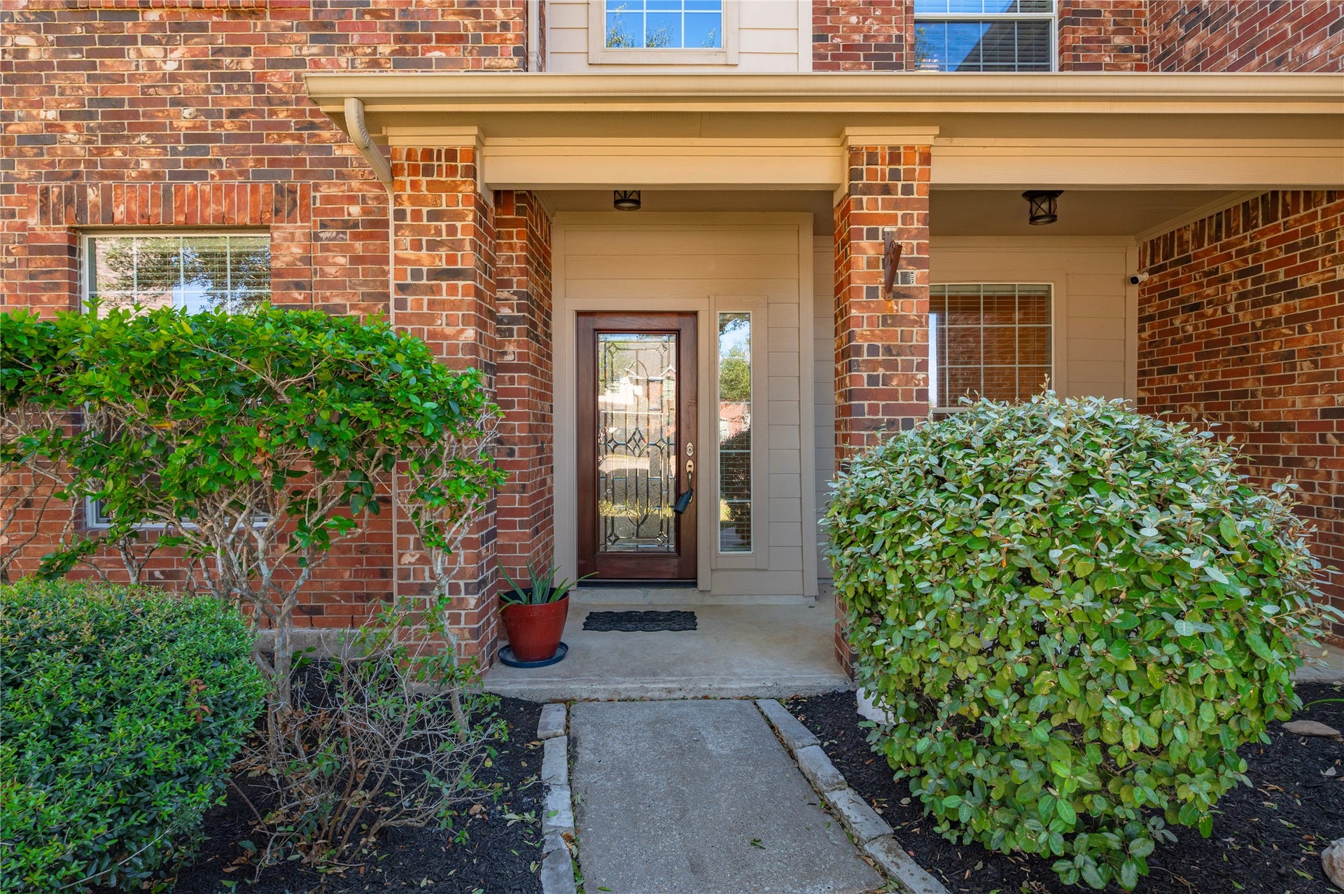 4404 Cypress Meadows Court, Dickinson, TX 77539 A welcoming front walkway leads to the wood front door with decorative glass panels.