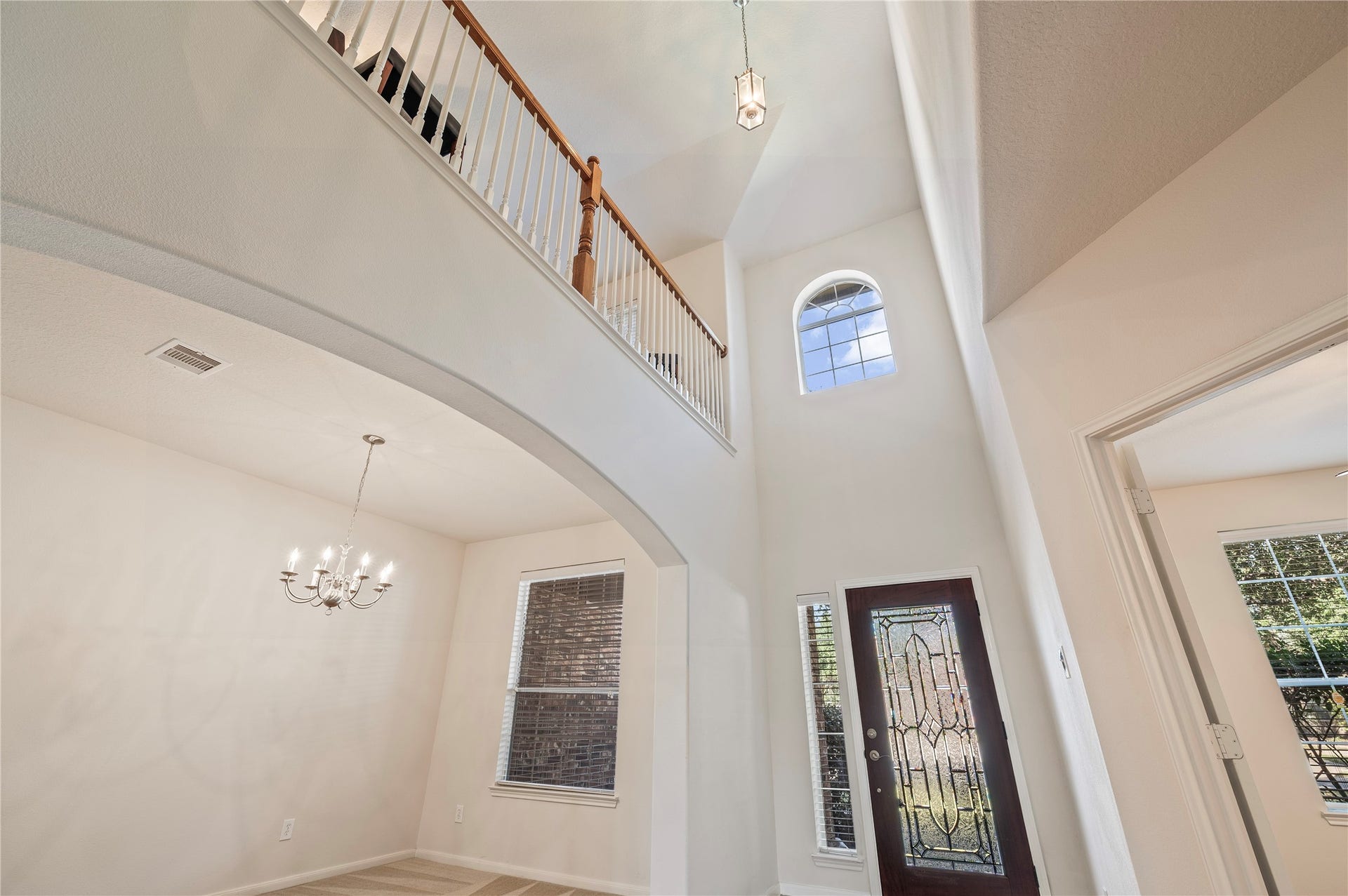 4404 Cypress Meadows Court, Dickinson, TX 77539 The open upstairs walkway overlooks the grand entry, highlighting the home's high ceilings and natural light.
