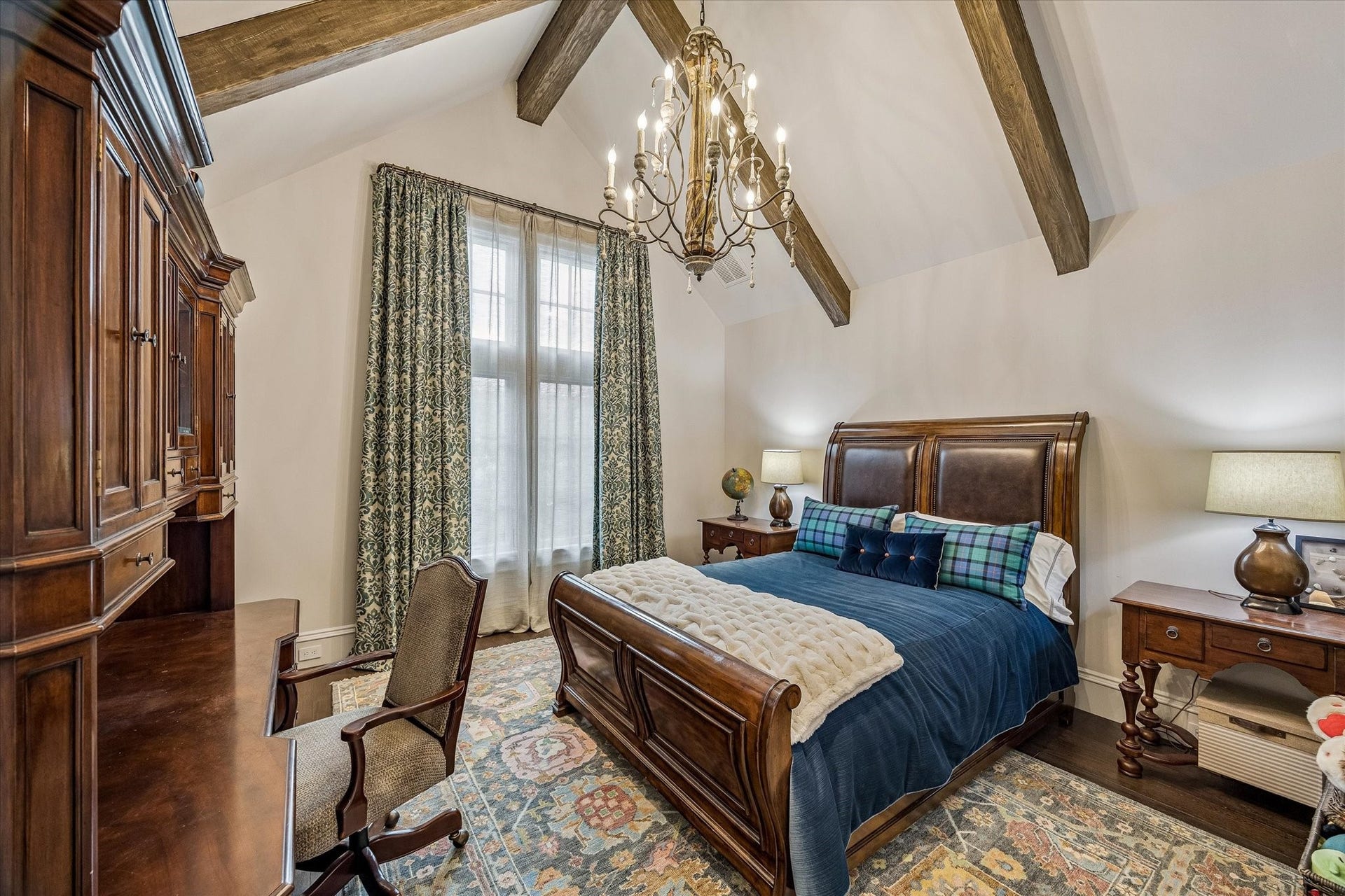 2158 Chilton Road, Houston, TX 77019 Guest Bedroom No. 1 offers vaulted ceilings with wood beams, western-facing windows, and custom treatments. Hardwood floors and designer lighting create a bright and inviting retreat with an en-suite bath.