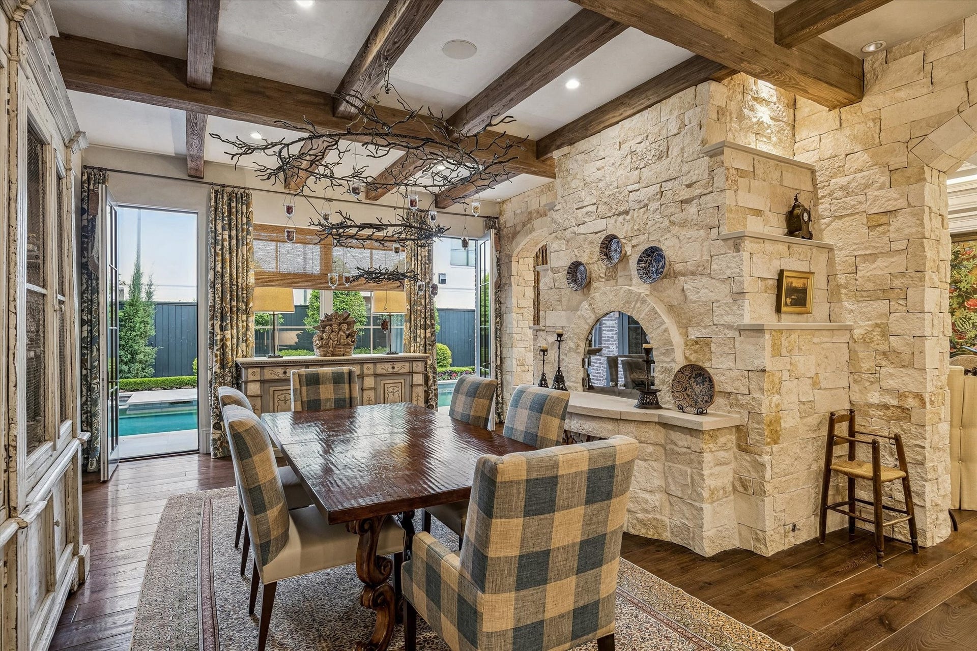 2158 Chilton Road, Houston, TX 77019 The breakfast room is a sunlit retreat with tranquil backyard and pool views, highlighted by a beamed and Segreto plaster ceiling and built-in speakers. A limestone-surround pizza oven/fireplace adds warmth and charm to this inviting space.