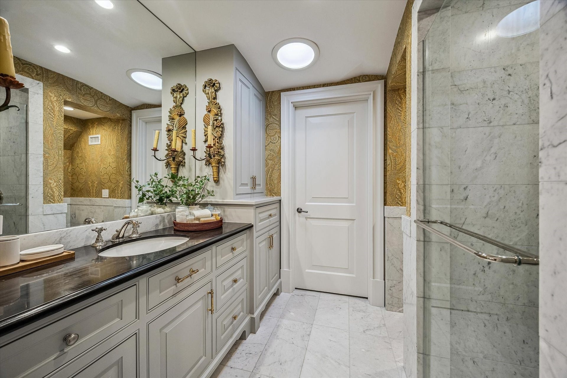 2158 Chilton Road, Houston, TX 77019 The ensuite bathroom No 4 exudes sophistication with marble floors and wainscoting, a walk-in shower with bench seating, and polished nickel fixtures. Designer wallpaper and high-end finishes complete this luxurious, spa-inspired space.