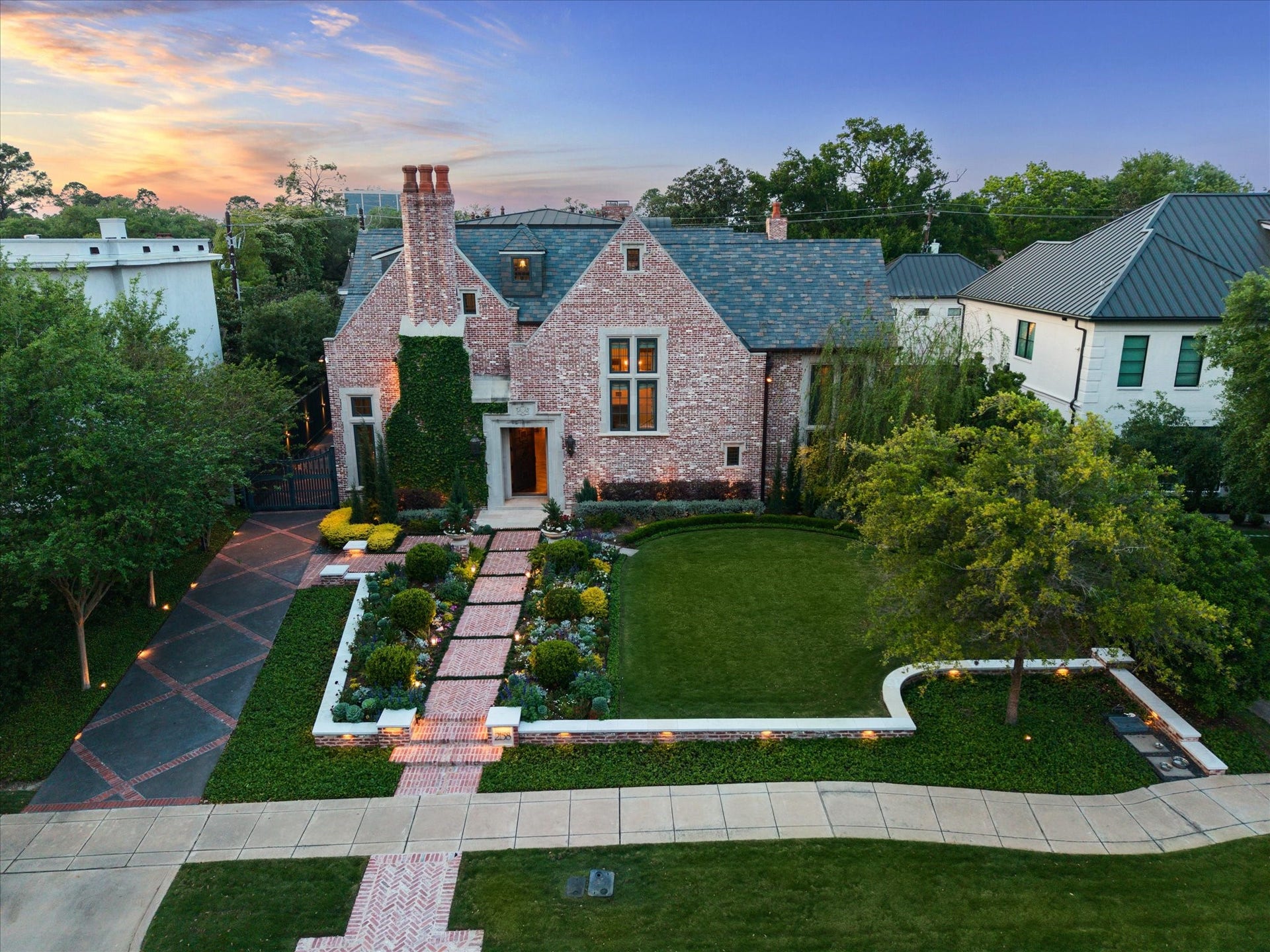 2158 Chilton Road, Houston, TX 77019 Located in prestigious River Oaks, this 5BD, 5.3BA home welcomes you with a spacious green lawn, manicured landscaping, and a stately two-car garage. The solid wood front door with dual lanterns sets an elegant tone for the interior.