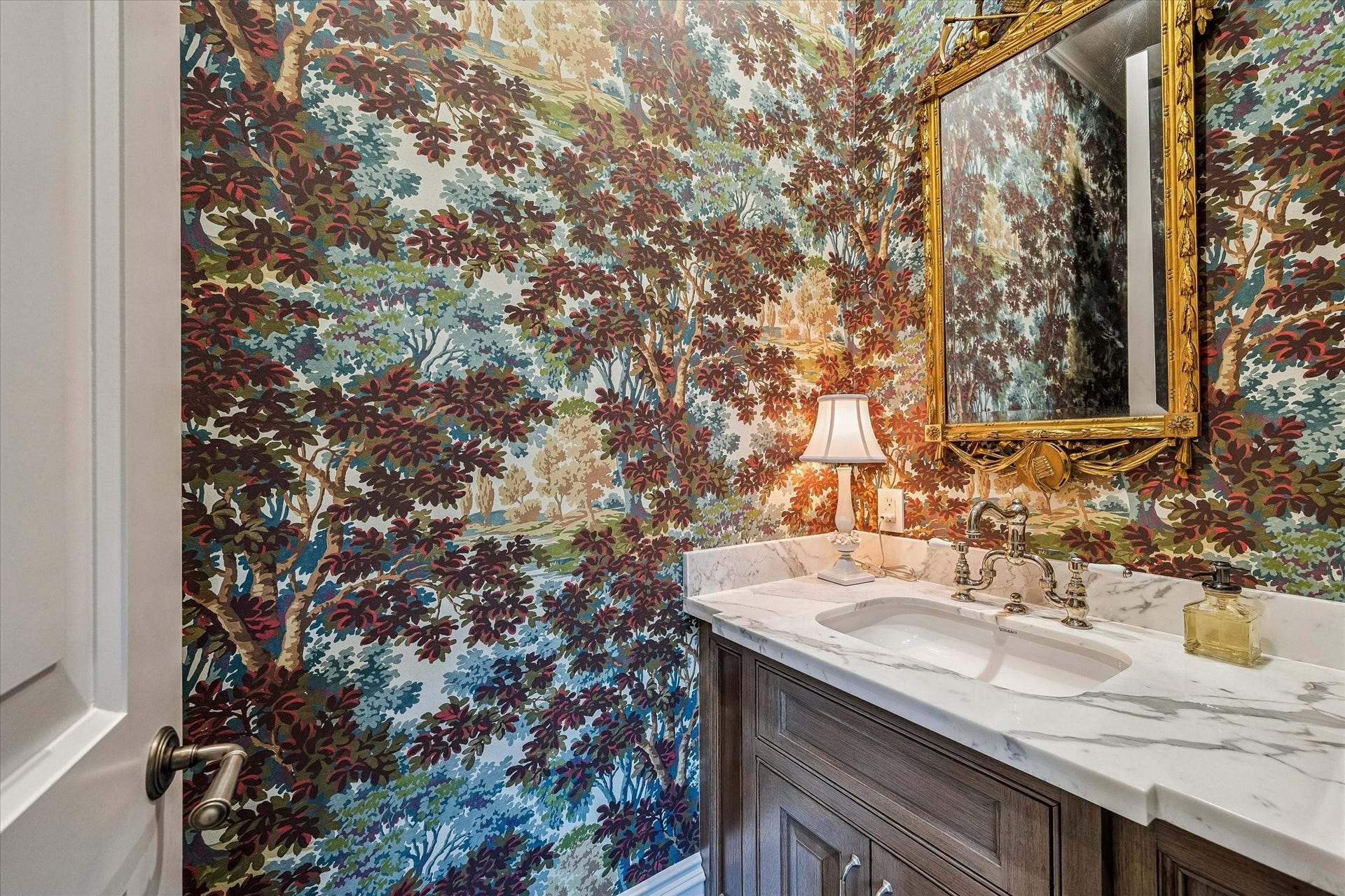 2158 Chilton Road, Houston, TX 77019 The powder room is richly appointed with designer wallpaper by Bunny Williams for Lee Jofa, elegant lighting, and marble countertops. Thoughtful details and refined finishes create a sophisticated and memorable space for guests.