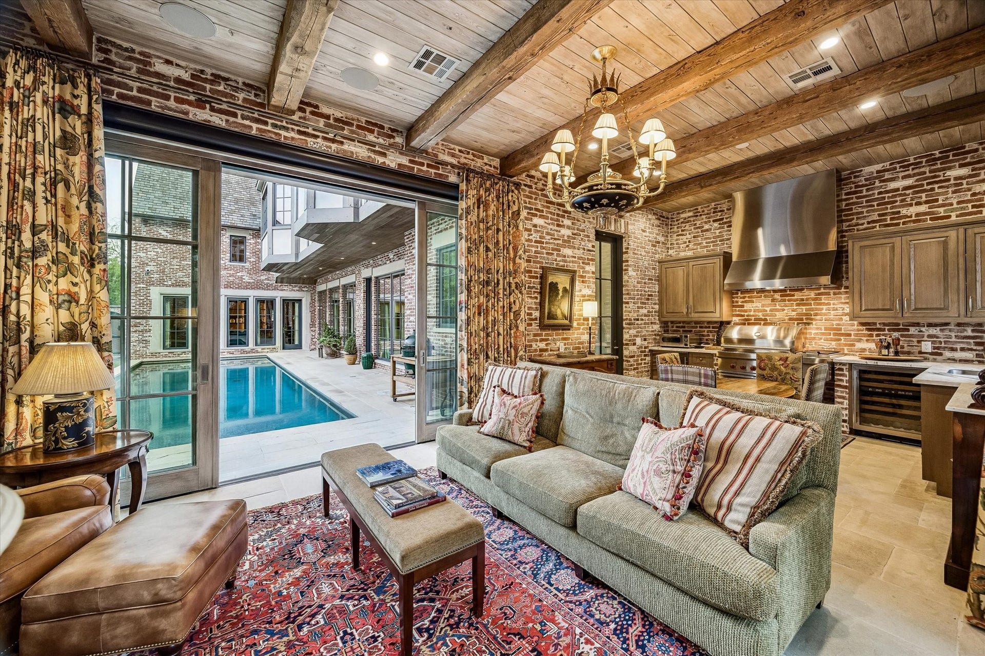 2158 Chilton Road, Houston, TX 77019 A beautifully designed retreat with brick walls and beamed ceiling, the air conditioned pool room captures serene garden and pool views. Complete with a fireplace and full-service kitchen, its ideal for both casual gatherings and elevated hosting. Remote control screens raise and lower at your convenience.