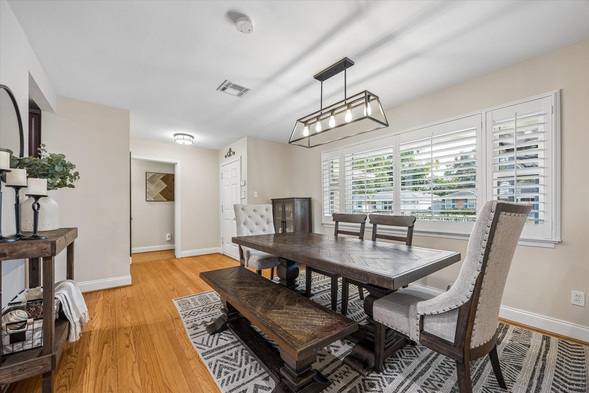 2318 Cheshire Lane, Houston, TX 77018 Front dining space offers flexibility for gathering without taking over the main living room. Wood floors continue toward the hallway, connecting the home's shared spaces with its bedroom wing.