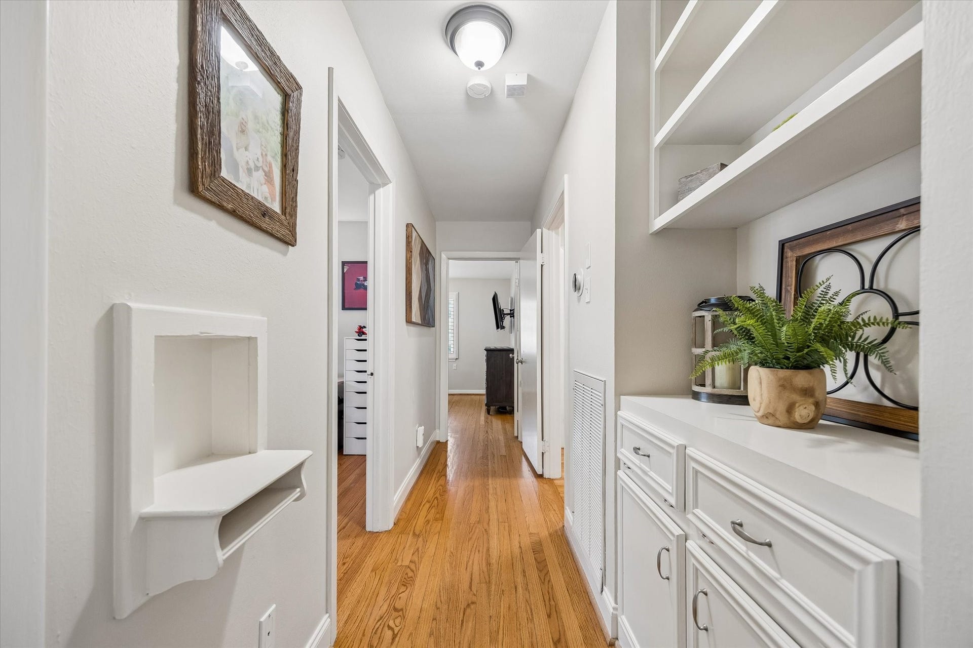 2318 Cheshire Lane, Houston, TX 77018 Hallway shelving and lower cabinets add storage along the route to the bedrooms. Open shelves and enclosed cabinetry provide space for books, linens and household essentials while keeping the passage clear.