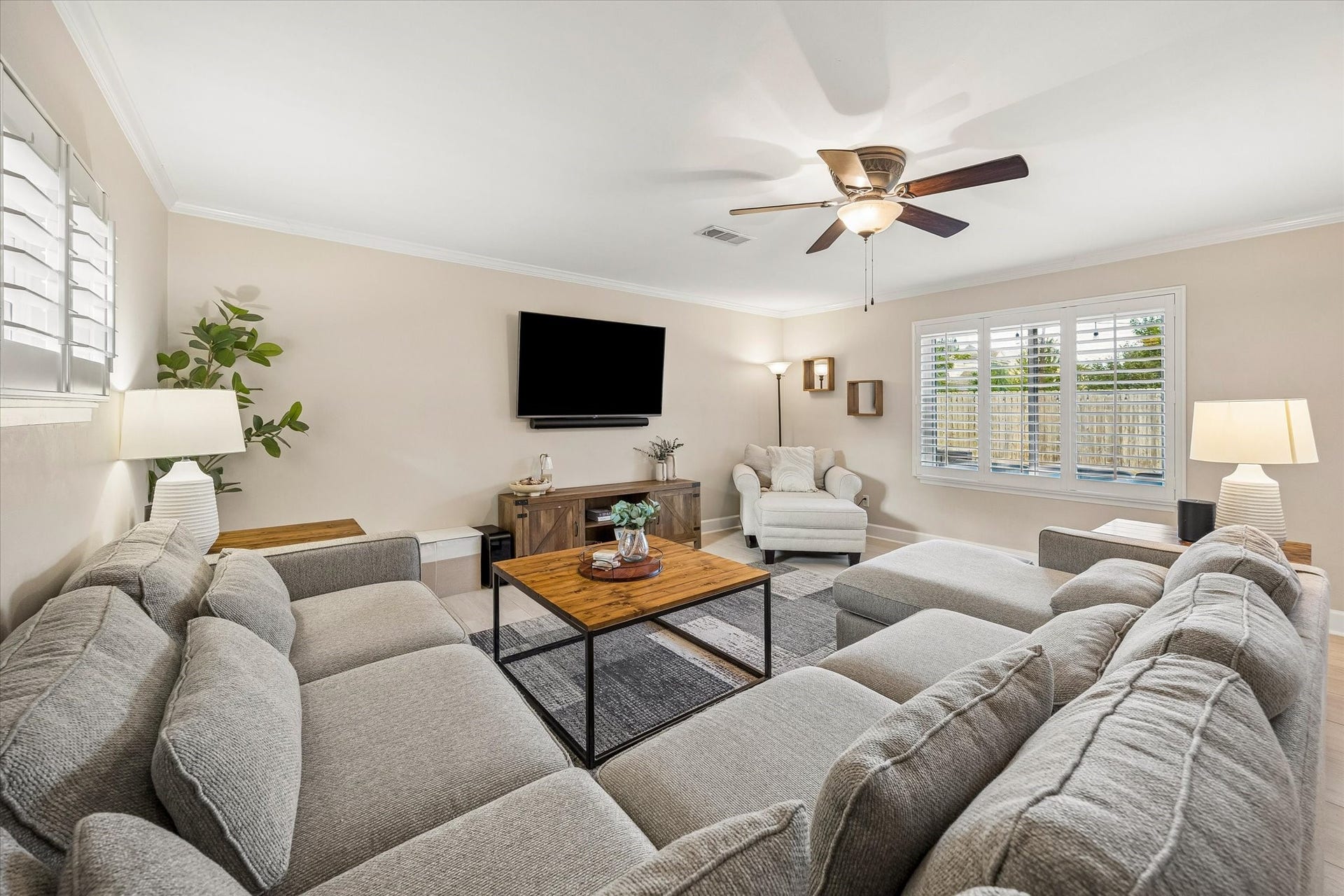 2318 Cheshire Lane, Houston, TX 77018 Windows and a glass exterior door bring backyard views into the living room. Direct outdoor access connects the main gathering space with the rear deck, making it easy to move between indoor and outdoor activities.