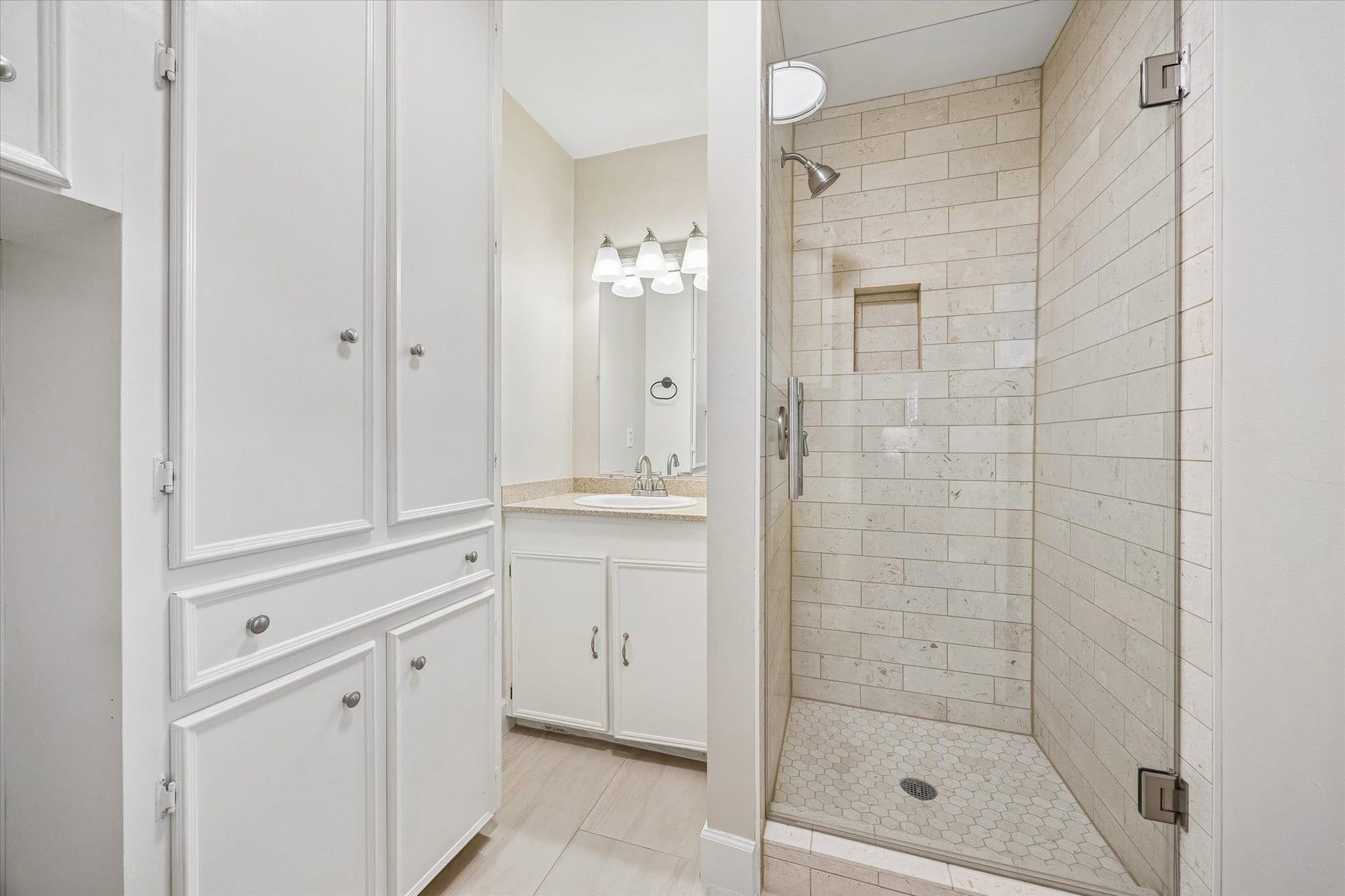 2318 Cheshire Lane, Houston, TX 77018 Glass enclosed shower features a recessed niche for bathing essentials, while tall cabinetry adds useful towel and linen storage. This full bath provides an additional bathing area separate from the bathroom near the bedrooms.