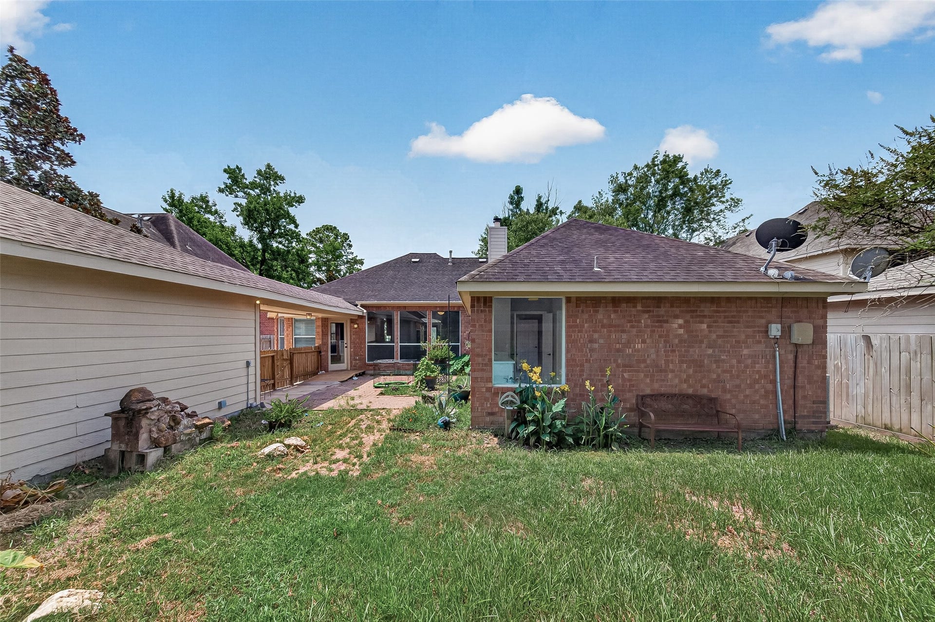 12823 Lady Jane Court, Houston, TX 77044 Charming backyard view with a brick exterior, inviting patio, and vibrant greenery, perfect for outdoor relaxation and entertaining.