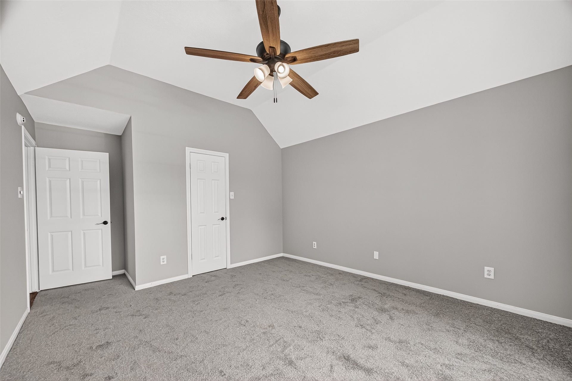 12823 Lady Jane Court, Houston, TX 77044 Spacious bedroom featuring a vaulted ceiling, modern ceiling fan, and plush carpeting, perfect for comfort and style.