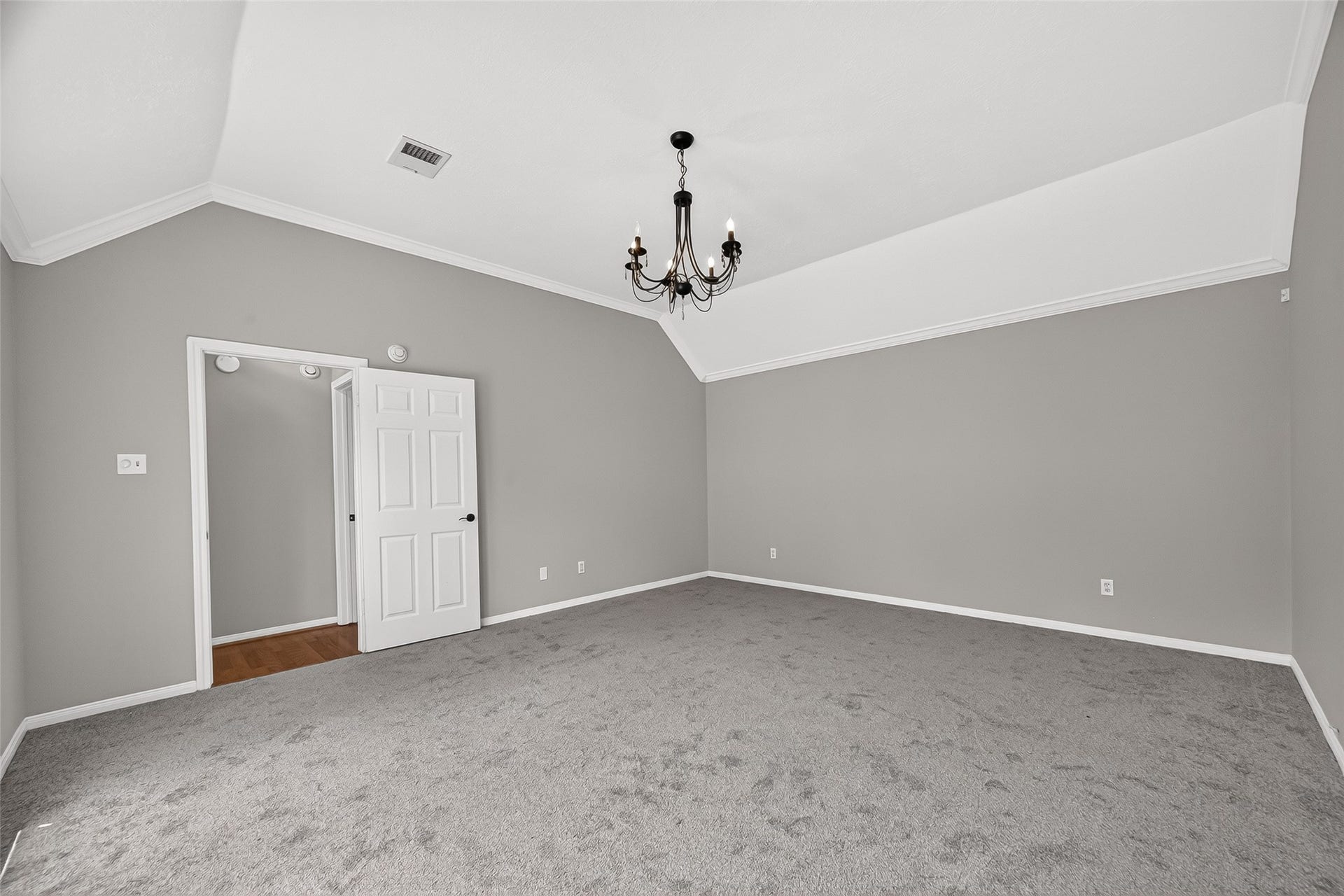 12823 Lady Jane Court, Houston, TX 77044 Spacious bedroom with vaulted ceilings, elegant chandelier, and plush carpet, offering a serene and inviting atmosphere.