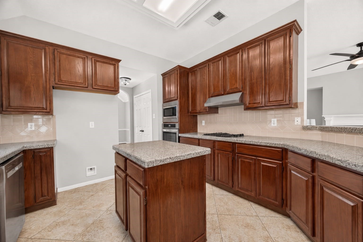 12823 Lady Jane Court, Houston, TX 77044 Spacious kitchen featuring rich wooden cabinetry, sleek granite countertops, and modern stainless steel appliances, perfect for culinary enthusiasts.
