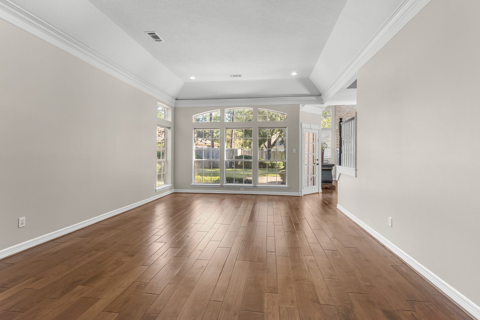 16314 Graven Hill Drive, Spring, TX 77379 A broad expanse of windows brings natural light into this spacious living area, complemented by warm wood flooring and a detailed ceiling.