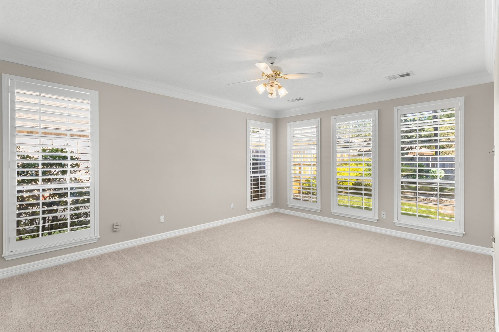 16314 Graven Hill Drive, Spring, TX 77379 A spacious first-floor bedroom features soft neutral finishes, plantation shutters and abundant windows for a serene retreat.