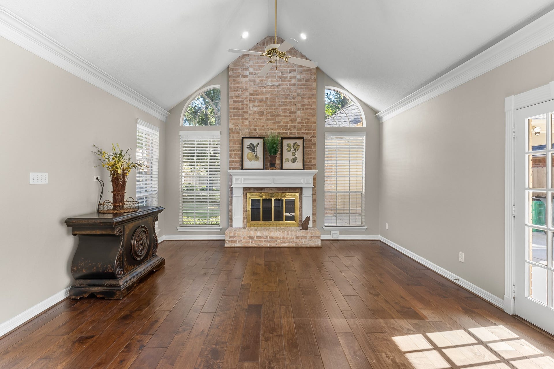 16314 Graven Hill Drive, Spring, TX 77379 The substantial brick fireplace and graceful arched windows create a striking focal point filled with natural light.