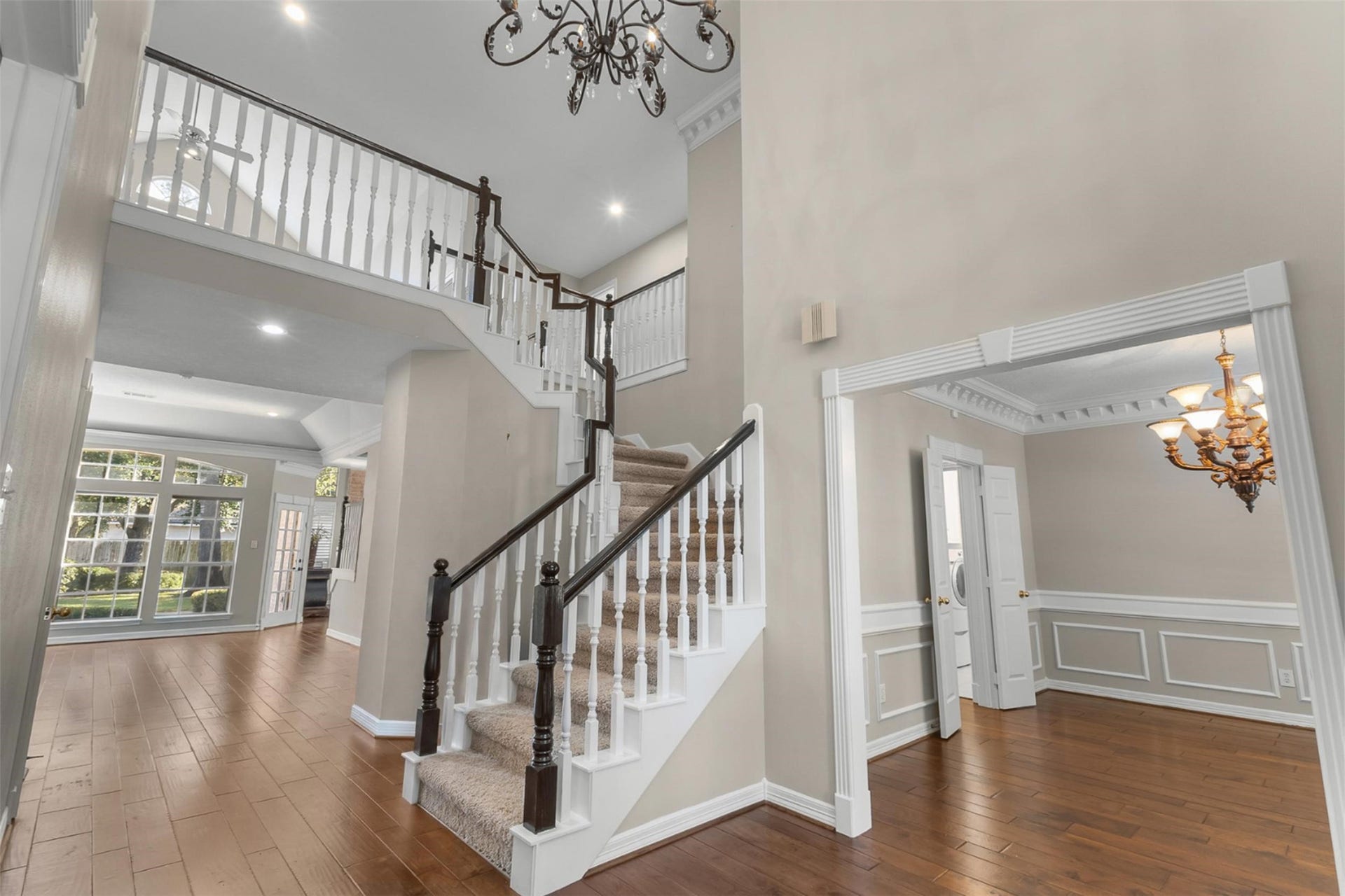 16314 Graven Hill Drive, Spring, TX 77379 This unobstructed view seamlessly captures the open-concept flow from the grand entry through the formal dining and living rooms, while offering a warm, inviting peek into the spacious family room beyond.